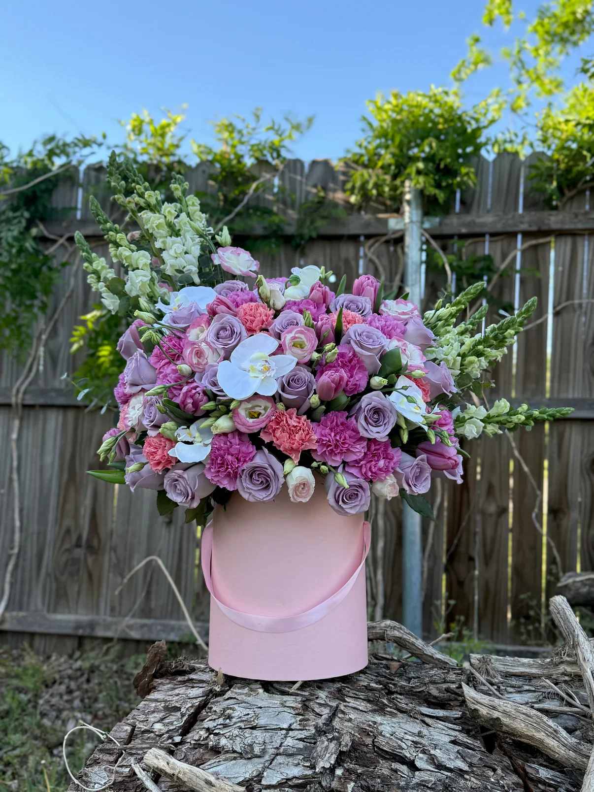 Caja de flores surtidas 5 - rosas lilas, tonos rosados vibrantes y delicadas orquídeas blancas, creando una pieza única llena de elegancia y armonía. Sus detalles verticales aportan un estilo moderno y exclusivo, perfecto para impresionar en cualquier ocasión especial.   Flores frescas premium  Diseño elegante y voluminoso  Ideal para cumpleaños, aniversarios o sorprender sin motivo  Ordena en línea y haz de cualquier momento algo inolvidable 