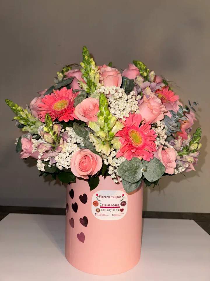Caja de flores surtidas 6 - Sorprende con este hermoso arreglo floral diseñado en una elegante caja cilíndrica color rosa decorada con delicados corazones. Una combinación perfecta de rosas en tonos suaves, vibrantes gerberas rosadas, finos detalles de nube (gypsophila), frescos toques de eucalipto y delicadas flores complementarias que crean un diseño armonioso, romántico y lleno de vida.  Ideal para cumpleaños, aniversarios, Día de la Mujer, San Valentín o simplemente para demostrar amor y cariño en cualquier ocasión especial.   Incluye:  Rosas en tonos pastel Gerberas rosadas Flores de relleno (nube) Eucalipto fresco Caja decorativa reutilizable    Diseño elegante, fresco y listo para regalar.  Elaborado con flores frescas de alta calidad.  Un detalle que transmite dulzura, elegancia y amor en cada pétalo. 