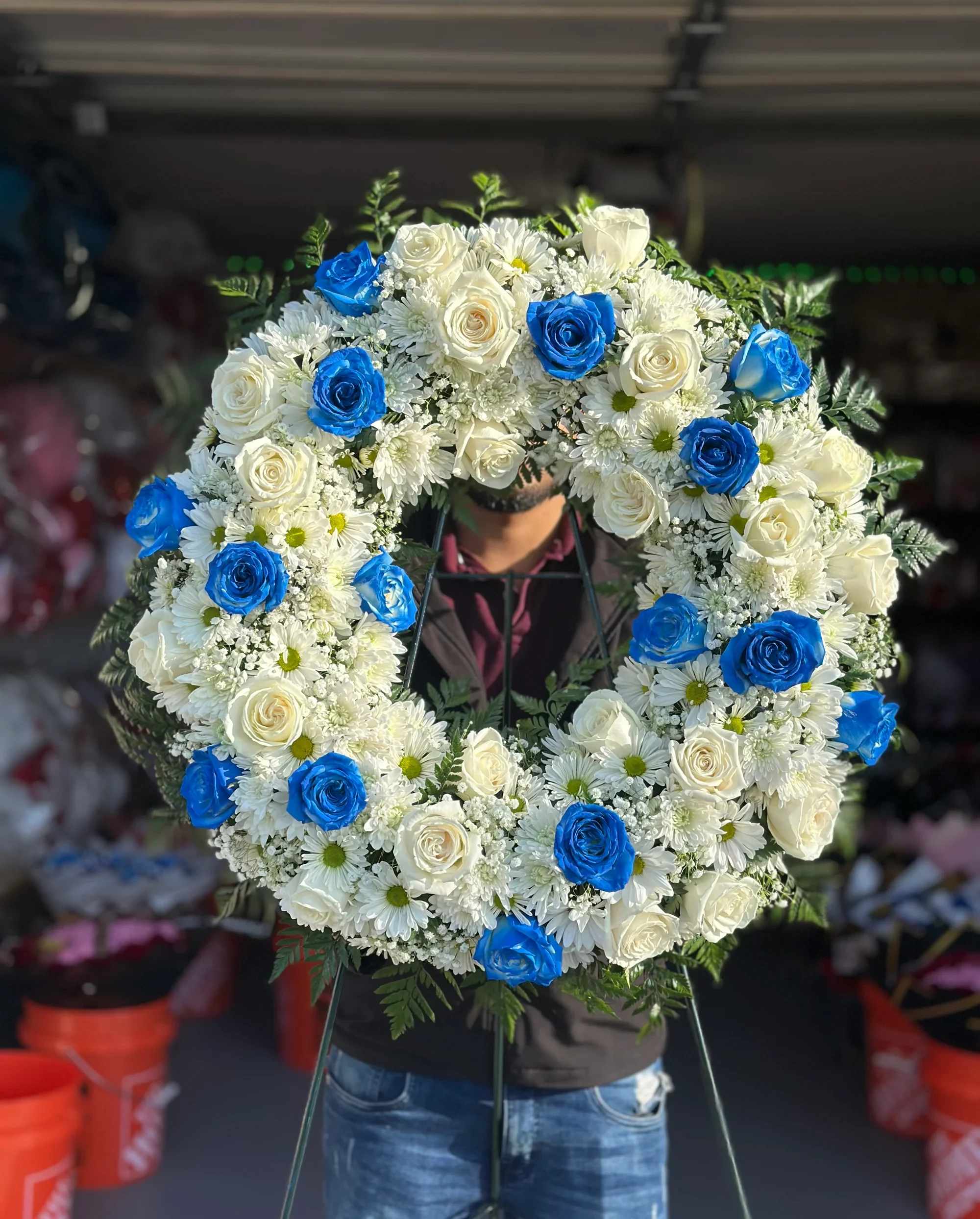 Corona 3 -  Corona Fúnebre Blanca “Paz Eterna” ️  Expresa tus condolencias con esta hermosa corona fúnebre en tonos blancos, símbolo de pureza, respeto y amor eterno. Su diseño circular representa la eternidad y el recuerdo que permanece para siempre en el corazón.  Elaborada con una delicada combinación de rosas blancas, margaritas, crisantemos y baby breath, complementadas con follaje verde natural que realza su elegancia y solemnidad.  Un arreglo clásico y distinguido, ideal para rendir homenaje con sensibilidad y buen gusto.   Detalles del producto:  Rosas blancas frescas Margaritas blancas Crisantemos blancos Flores de relleno (baby breath) Follaje verde natural Base metálica incluida   ️ Ideal para funerales, servicios memoriales o ceremonias de despedida.   Un tributo floral que transmite paz y acompañamiento en momentos difíciles.