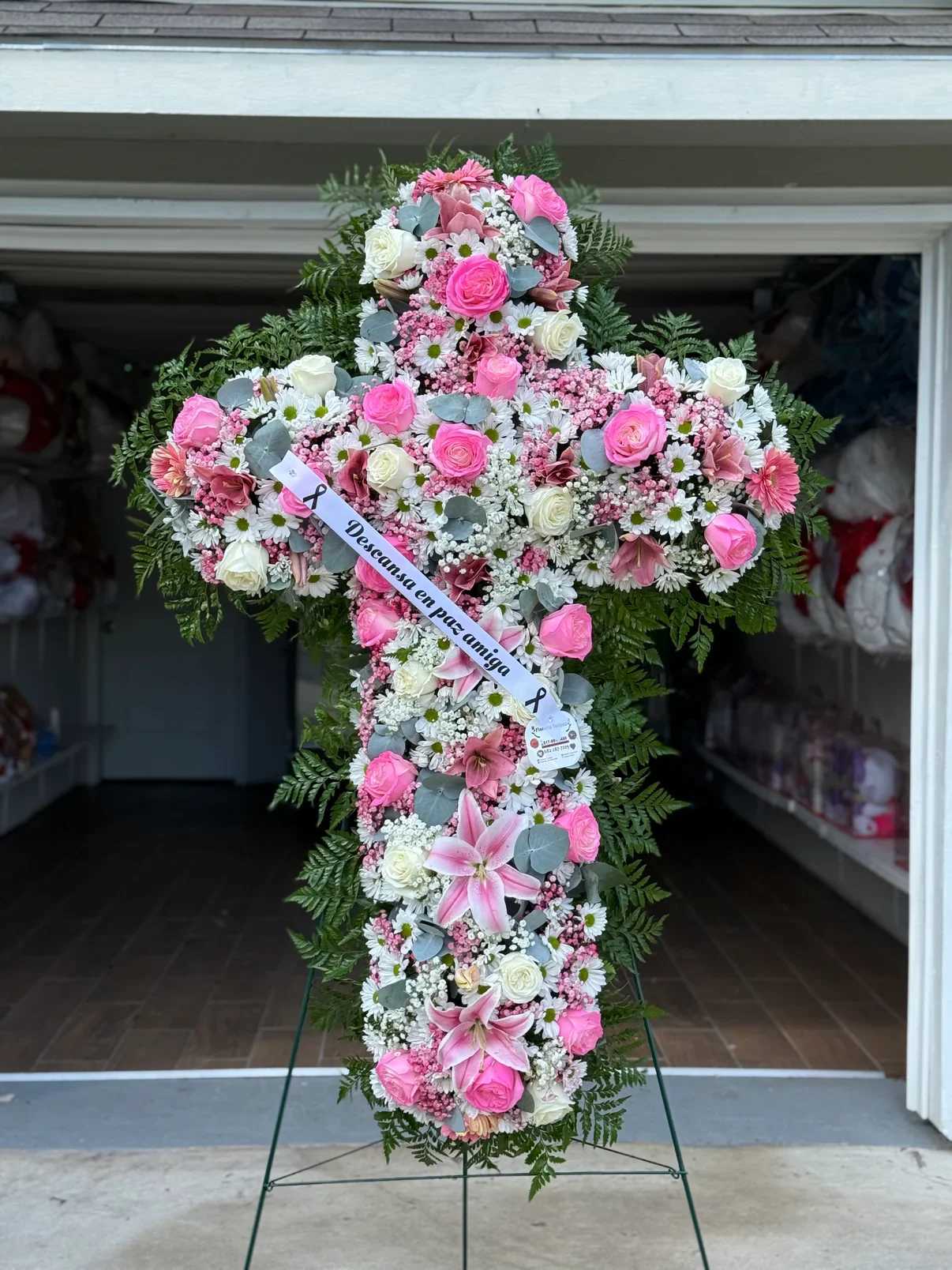 Cruz 2 - ️ Cruz Fúnebre Rosa “Luz y Esperanza”   Honra la memoria de tu ser querido con esta majestuosa cruz floral en tonos blancos, símbolo de pureza, fe y paz eterna.  Diseñada con una delicada combinación de rosas blancas, margaritas, crisantemos y baby breath, cuidadosamente distribuidas para crear un acabado lleno y armonioso. El follaje verde natural realza su elegancia y aporta un contraste sutil y distinguido.  Su diseño en forma de cruz representa esperanza y consuelo, convirtiéndola en un tributo significativo para momentos de despedida.    Detalles del producto:  Rosas blancas frescas Margaritas blancas Crisantemos blancos Flores de relleno (baby breath) Follaje verde natural Base de madera incluida   ️ Ideal para funerales, velorios y ceremonias religiosas.   Un arreglo solemne y elegante que expresa respeto, amor y acompañamiento.