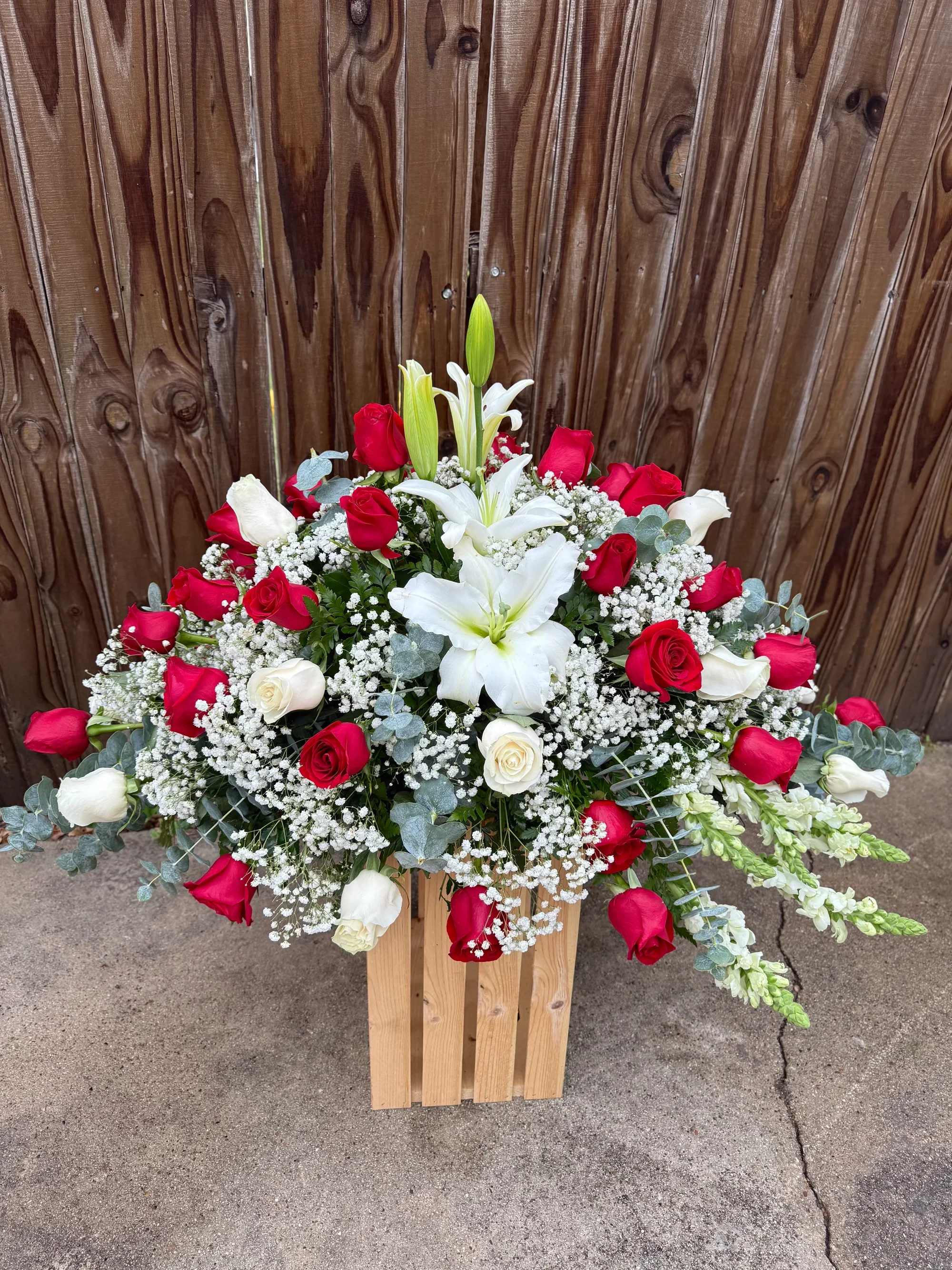Cubre caja 2 - Hermoso arreglo floral elaborado con delicadas rosas rojas y blancas, acompañado de un elegante lirio blanco central, rodeado de suaves flores de baby’s breath (gypsophila) y follaje fresco. Su diseño amplio y armonioso transmite amor, respeto y paz, creando una presentación sofisticada y llena de significado.  Este arreglo es ideal para expresar condolencias, amor y apoyo en momentos especiales, así como para ceremonias, memoriales o servicios funerarios. Cada flor es seleccionada cuidadosamente para garantizar frescura, belleza y un diseño elegante.   Rosas frescas de alta calidad   Lirio blanco que simboliza paz y pureza   Follaje natural que resalta su elegancia   Entrega disponible en Fort Worth, Dallas, Arlington, Grand Prairie e Irving  Un arreglo floral diseñado para honrar y recordar con amor a esa persona especial.