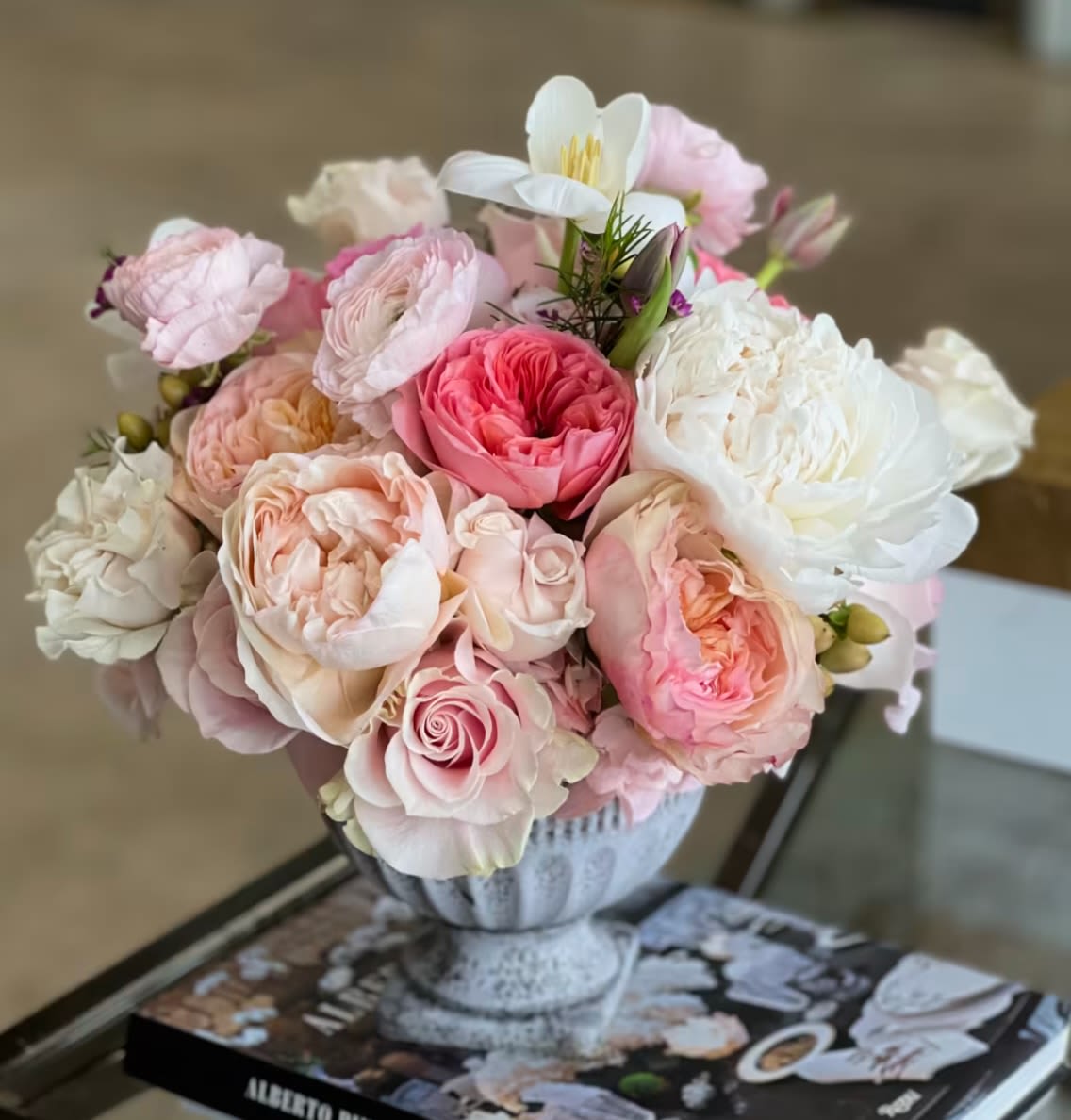 Pink and white rose bouquet in a decorative urn vase