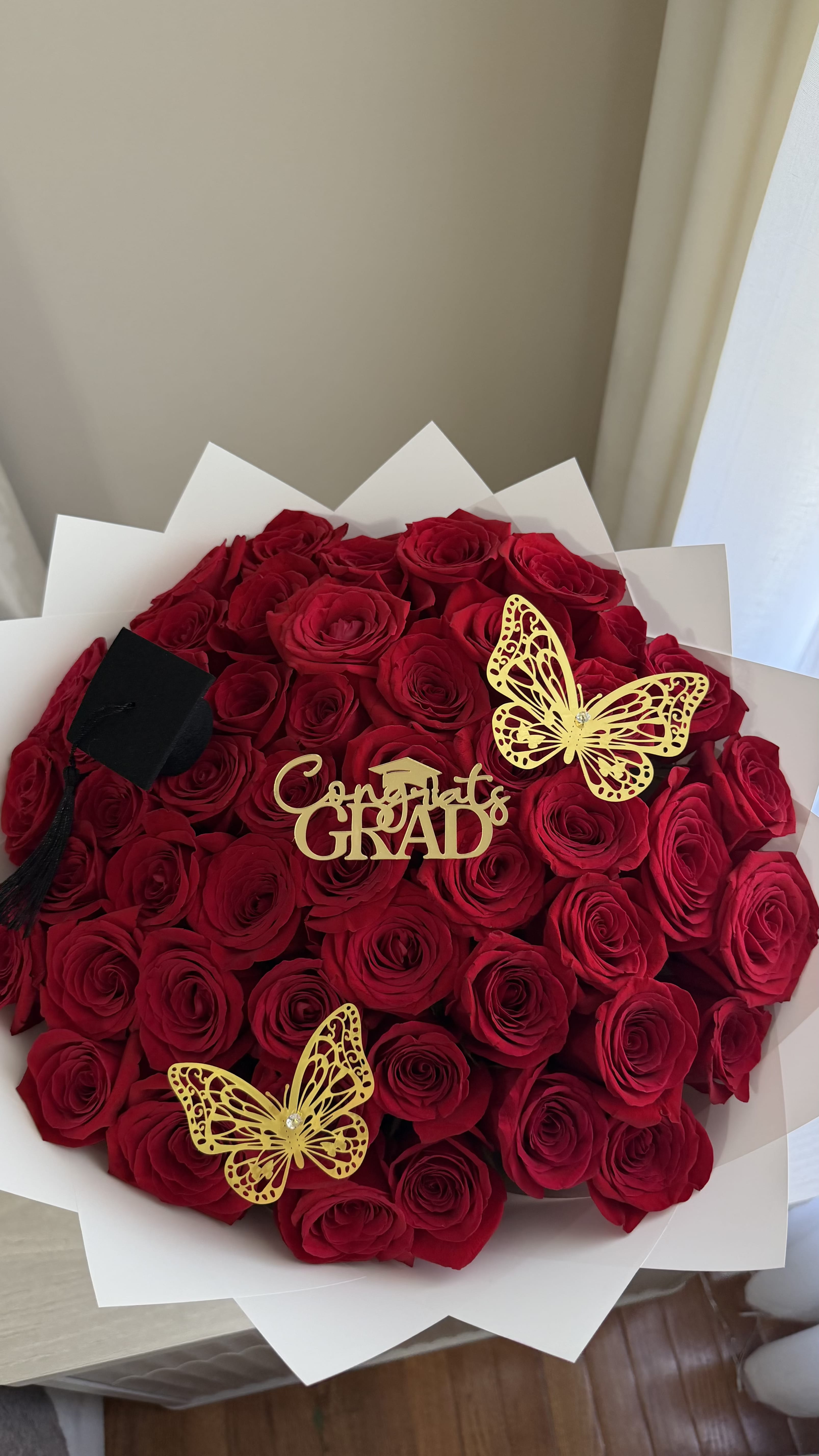 Congrats Grad ! - 50 count red roses graduation bouquet with white wrap, gold butterflies and a cap!