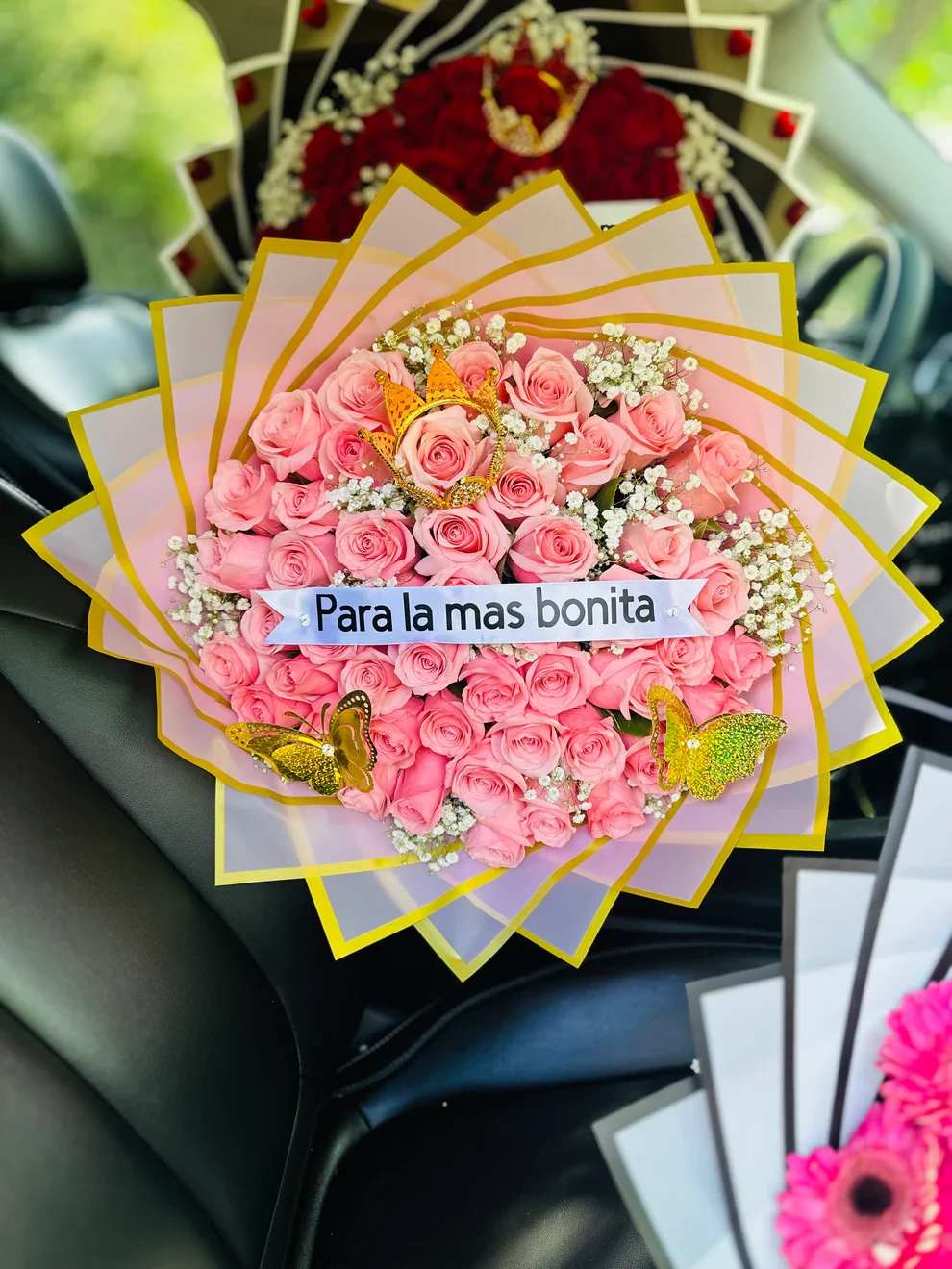 Ramo buchon 8 -  Bouquet “Para la Más Bonita”   Sorprende con un detalle lleno de ternura y elegancia. Este hermoso bouquet está compuesto por delicadas rosas rosadas premium, cuidadosamente acomodadas para crear un diseño voluminoso y sofisticado.  Incluye una hermosa corona decorativa dorada, mariposas brillantes y detalles de flores blancas que realzan su belleza. El mensaje “Para la más bonita” lo convierte en el regalo perfecto para hacer sentir especial a esa persona única.  Su envoltura en tonos suaves con borde amarillo le da un toque moderno y llamativo que enamora a primera vista.   Detalles del producto:   Rosas rosadas frescas premium Decoración con corona dorada Mariposas decorativas Flores de relleno blancas Frase incluida (personalizable) Presentación elegante lista para regalar    Ideal para cumpleaños, aniversarios, Día de la Madre o simplemente para sorprender.   Un detalle delicado, femenino y lleno de amor.