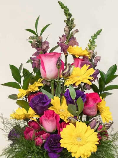 Designer's Choice Bright Tall - A vibrant, uplifting expression of color and movement, our Designer’s Choice Bright Tall Arrangement is designed in a lively palette of bold, cheerful blooms. Sunlit yellows, vivid oranges, hot pinks, bright corals, and energetic greens come together in a curated mix of premium seasonal flowers chosen fresh by our designer for height, texture, and joyful presence.  Arranged in an elongated, sculptural silhouette, this design radiates warmth and optimism — full of dynamic lines, rich color, and modern elegance. Perfect for celebrations, birthdays, thank‑yous, or adding a striking burst of brightness to any space.