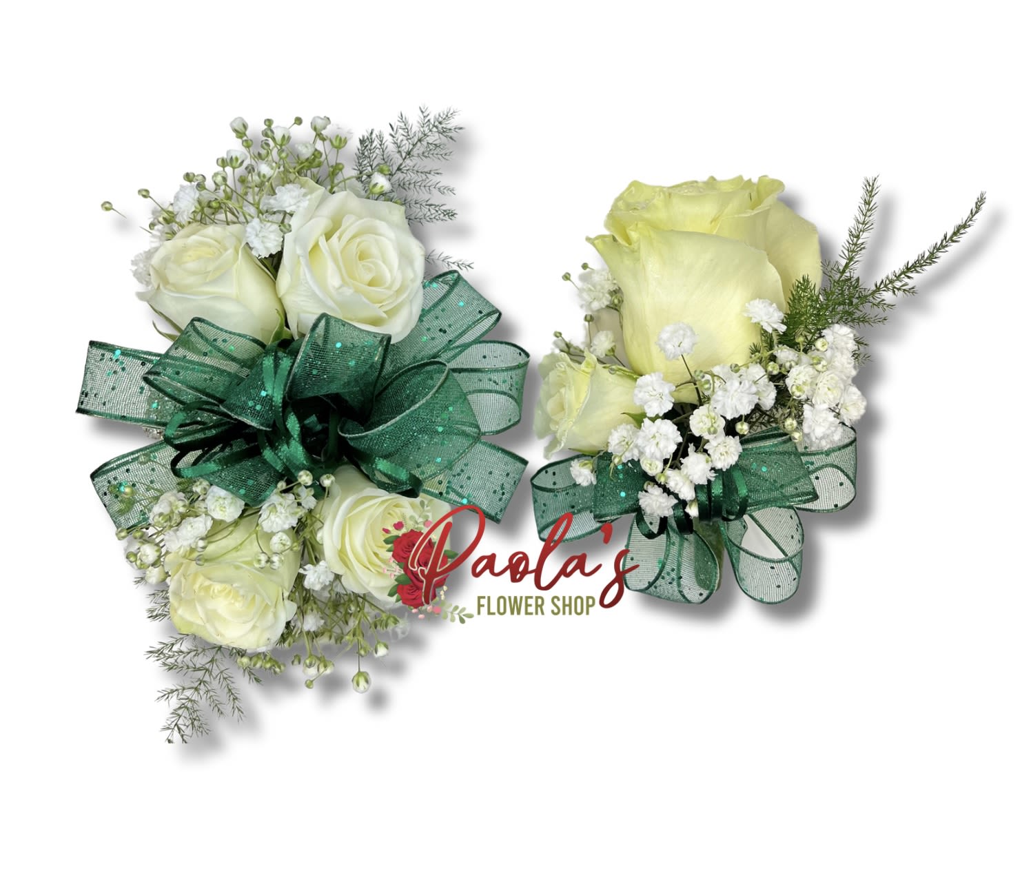 Two white rose corsages with green ribbon bows and baby's breath