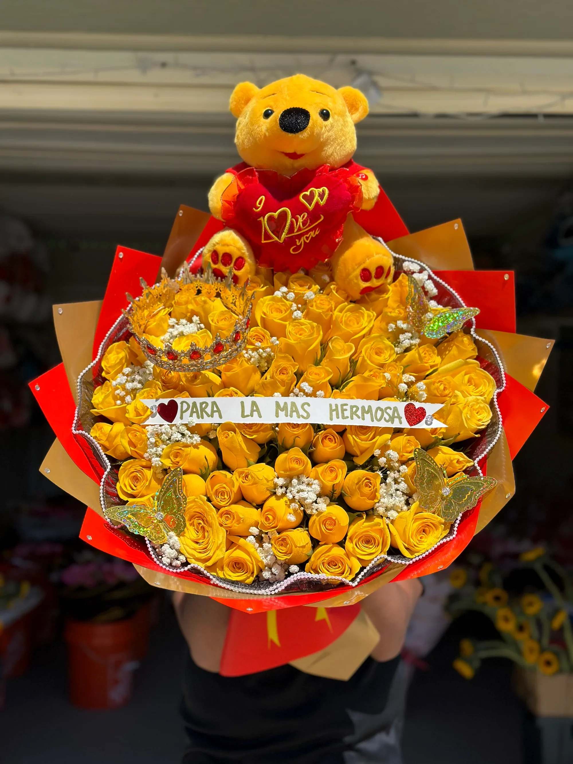 Ramo buchon 23 - Sorprende en su día especial con este hermoso y elegante arreglo floral en forma de corazón, elaborado con rosas rojas y amarillas de alta calidad. Un diseño vibrante que combina pasión, alegría y amor en cada detalle.  Incluye:   Rosas rojas y amarillas frescas  Delicados detalles de flor blanca (baby’s breath)  Moño decorativo elegante  Hermosas mariposas decorativas  Banda personalizada con el mensaje “Feliz cumpleaños bonita”  Perfecto para cumpleaños, aniversarios o para expresar amor y admiración de una manera inolvidable. Su presentación moderna y sofisticada lo convierte en el regalo ideal para sorprender y enamorar.   Disponible para entrega especial.  Producto elaborado con flores frescas y diseño artesanal.