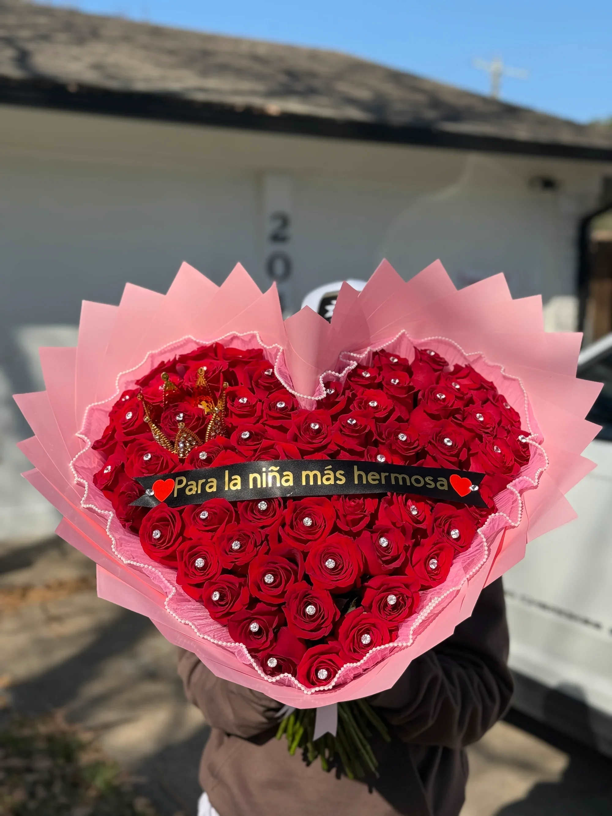 Ramo de corazón 2 -  Ramo Corazón “Para la niña más hermosa” – Edición Princesa   Hazla sentir única y especial con este espectacular ramo en forma de corazón, elaborado con hermosas rosas rojas frescas cuidadosamente acomodadas para crear un diseño impactante y romántico.  Cada rosa lleva un delicado detalle brillante que le da un toque elegante y sofisticado. Incluye una pequeña corona decorativa y el mensaje: “Para la niña más hermosa”, perfecto para expresar amor, admiración y ternura.   Detalles que enamoran:  • Rosas rojas frescas premium • Diseño en forma de corazón • Aplicaciones brillantes decorativas • Corona decorativa elegante • Envoltura en tonos rosa con acabado delicado • Listo para regalar   Ideal para:  • San Valentín • Cumpleaños • Aniversarios • Sorpresas románticas • Detalles especiales para alguien muy importante   Un ramo que combina romanticismo, elegancia y un mensaje lleno de amor. Perfecto para hacerla sentir como una verdadera princesa. ️  Ordena hoy y regala un momento inolvidable.