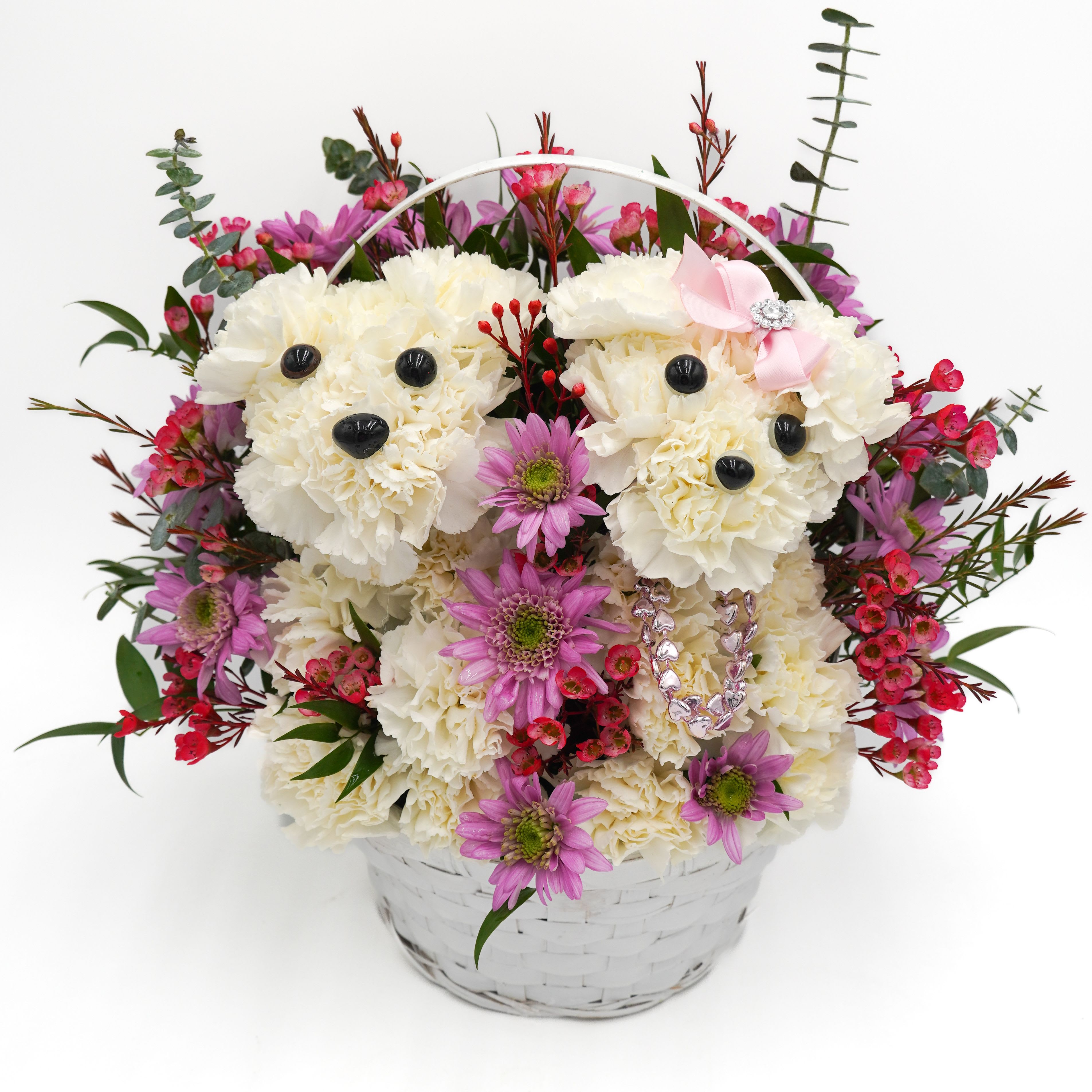 Sweetheart Pups Basket - Two adorable puppies made from fresh white carnations in a basket and surrounded by mixed pink and lavender flowers. A sweet arrangement that’s perfect for spreading love and smiles.