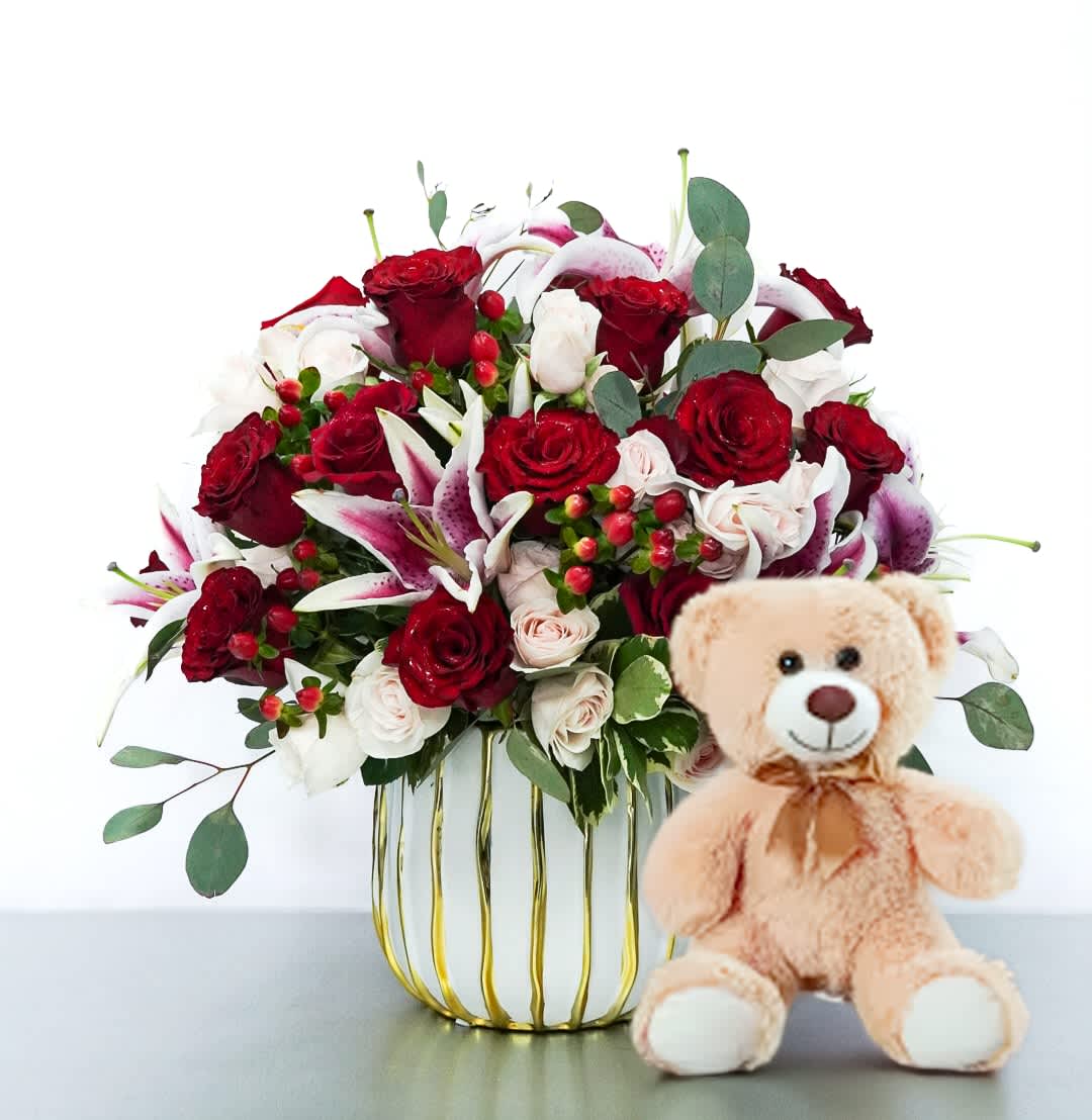 Roses &amp; Lilies with a Bear by Atlanta's Finest Flowers   - A mix of red, pink roses, and white lilies, accented with fresh greenery and berries, all arranged in a modern white and gold vase plus a cuddly teddy bear on the side. Perfect for celebrating love, just because, and much more.  Flower are arranged in a White and Gold Vase  13" Teddy Bear Is INCLUDED 
