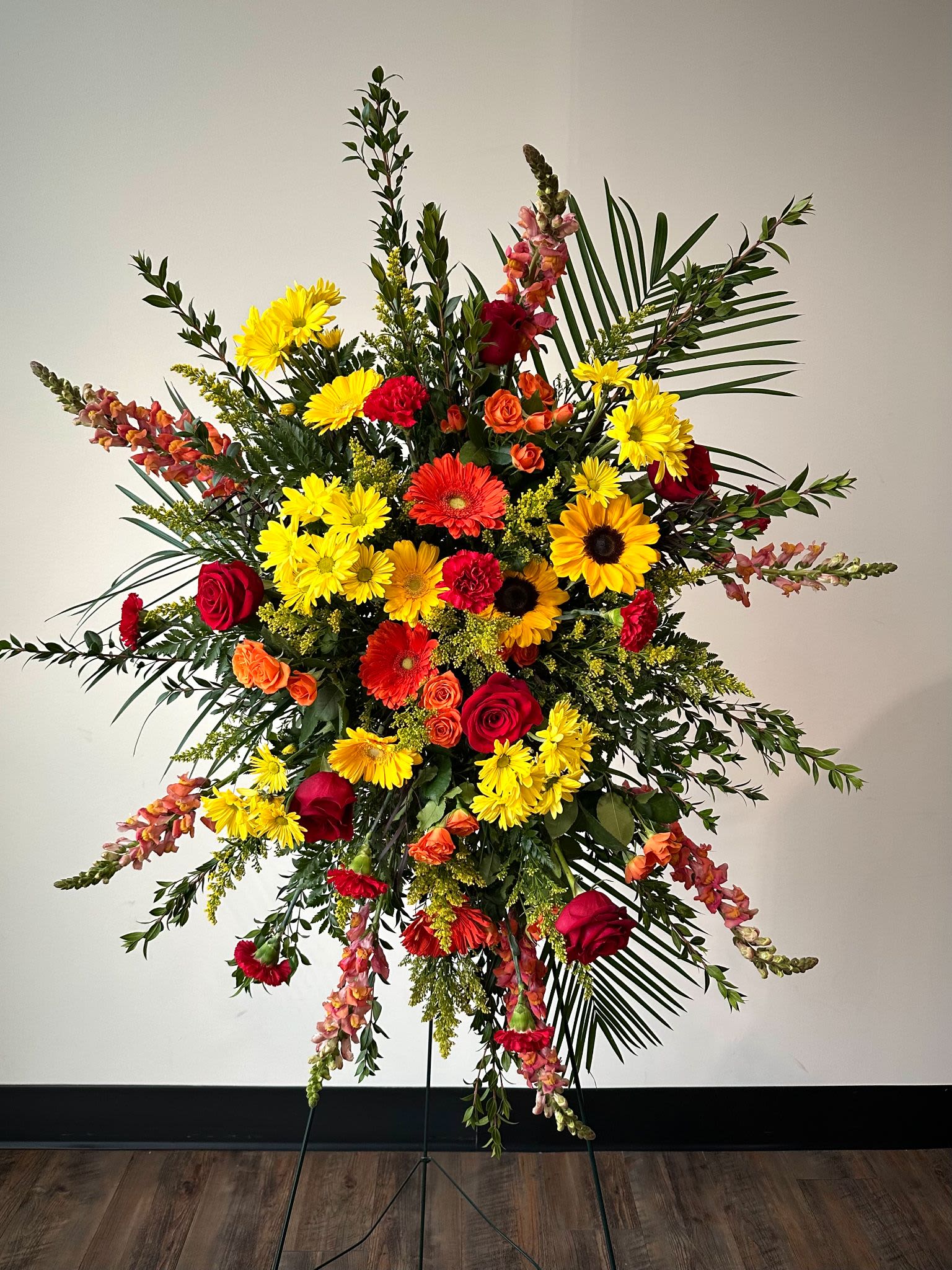 Tall standing floral spray with red, yellow, and orange blooms