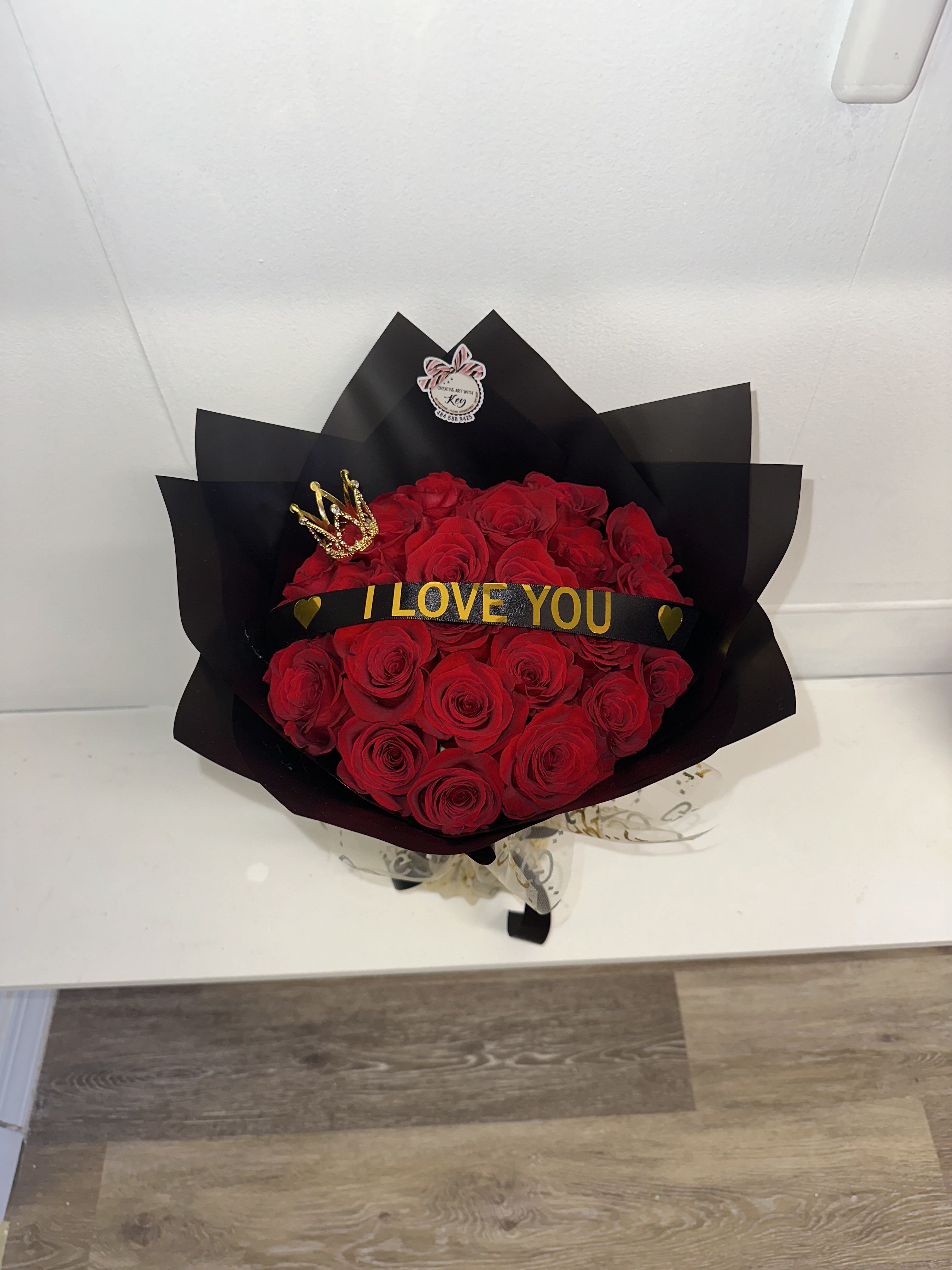 Bouquet of red roses wrapped in black paper with an "I LOVE YOU" ribbon