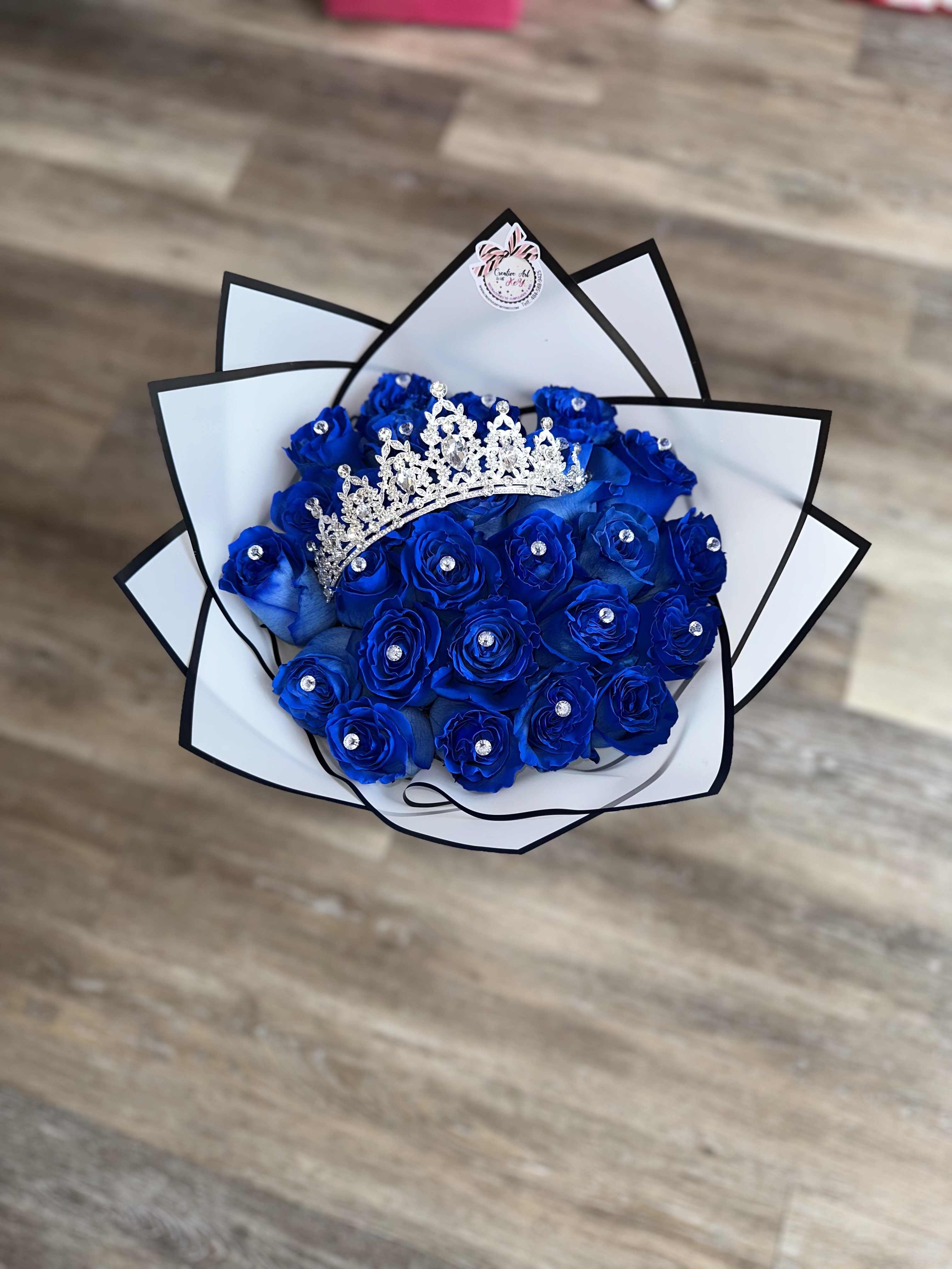 Blue rose bouquet with a jeweled tiara and white-black wrap