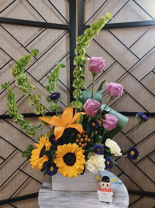 Mixed bouquet with sunflowers, pink roses, and orange lilies in a white box