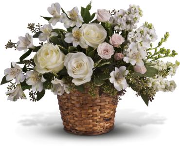 White roses and pale flowers arranged in a woven basket