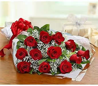 Bouquet of red roses with white filler flowers wrapped in paper