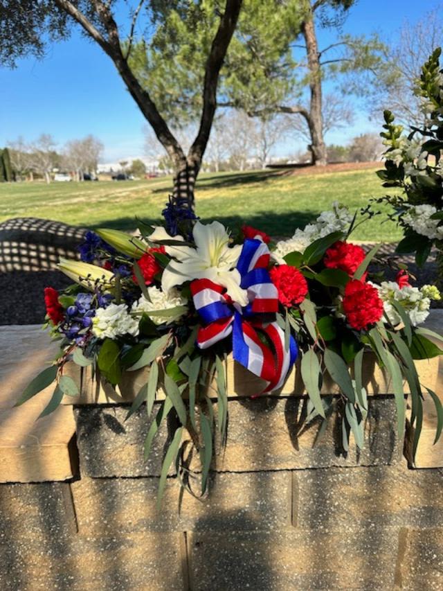 Forever Loved Urn Adornment   - This Service piece is designed to sit long and low in front of an urn or wooden box. At the National Cemetery it will be placed for you at the front of the middle column with room for the urn behind it. It's the also the perfect size to sit in front of an 8X10 photo.  