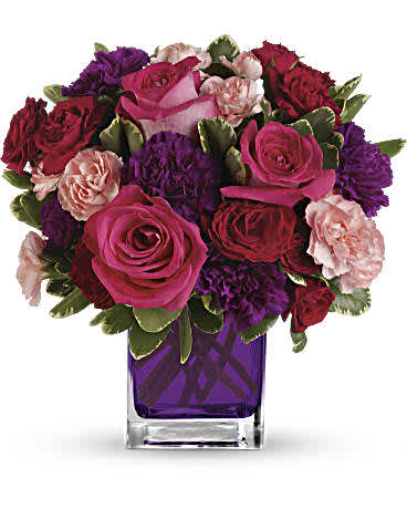 Bouquet of pink, red, and purple roses in a purple glass vase
