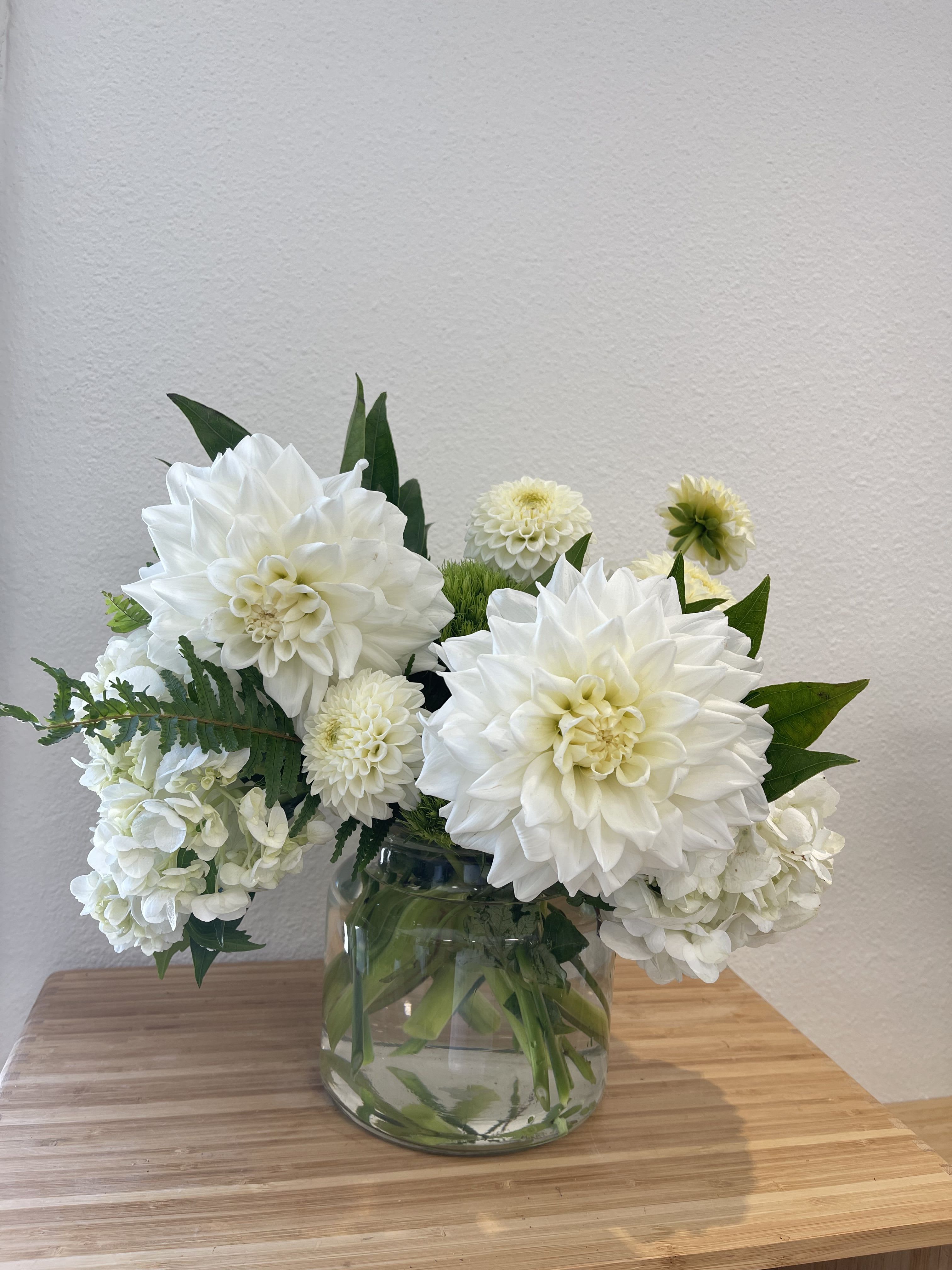 Bliss - Puffy white flowers in a clear cylinder vase.