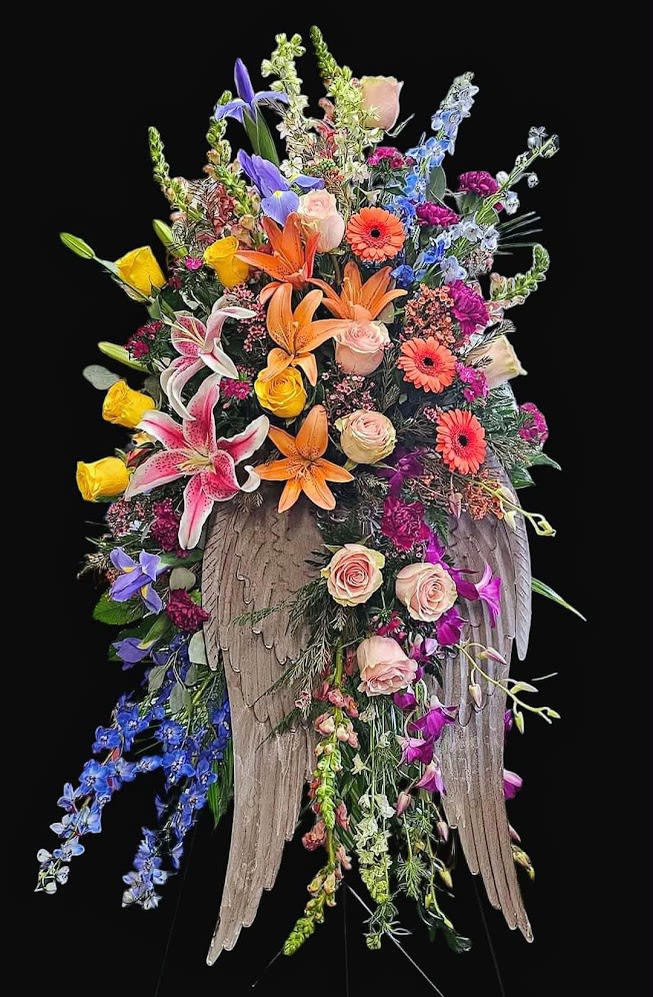 Heaven's Garden - A breathtaking angel-wing tribute overflowing with vibrant lilies, roses, and seasonal blooms. Designed to celebrate a cherished life with beauty, love, and hope while offering comfort to family and friends.