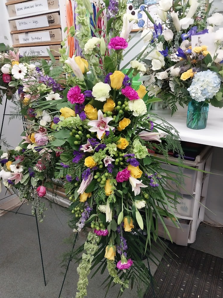 A Beautiful Journey - A lush garden-style tribute featuring roses, lilies, seasonal blooms