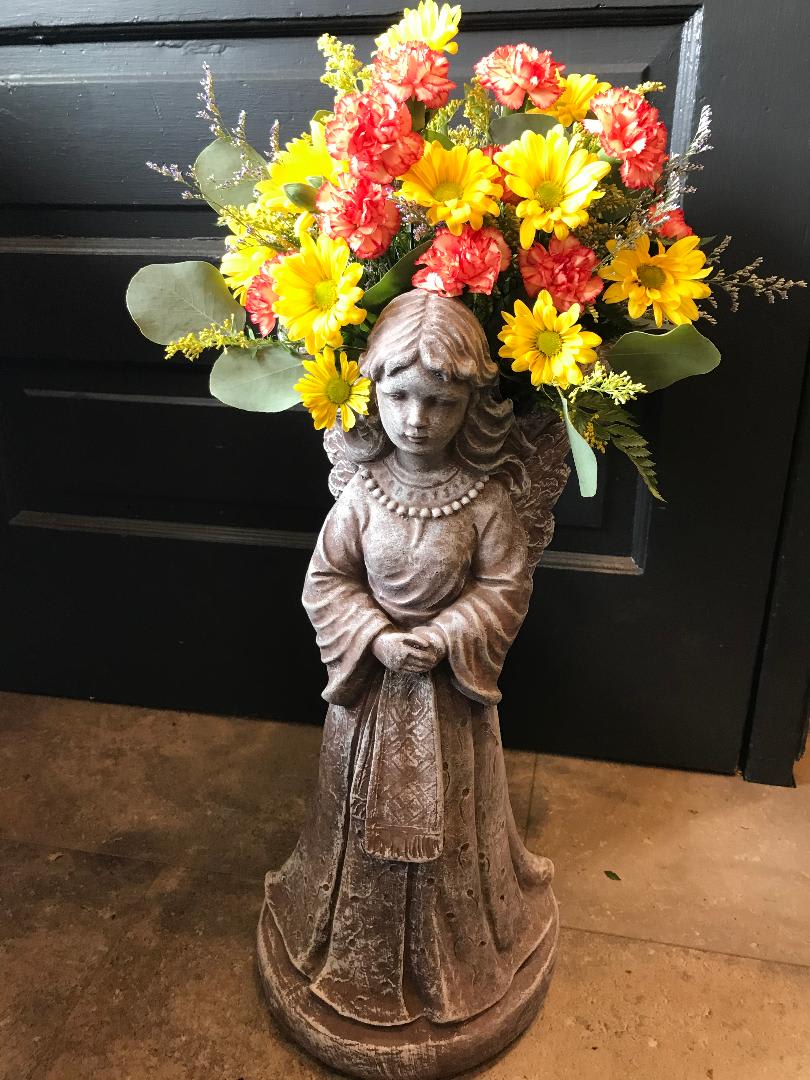 Flower arrangement on a girl statue with yellow and red blooms