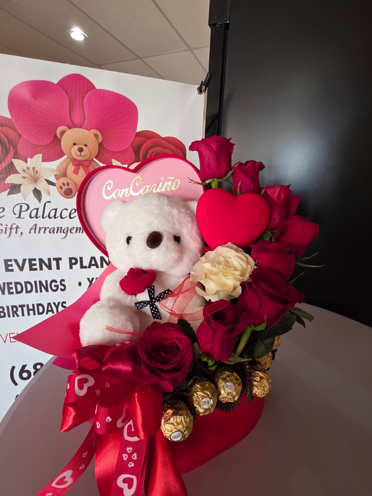 Heart-shaped rose arrangement with a teddy bear and chocolates