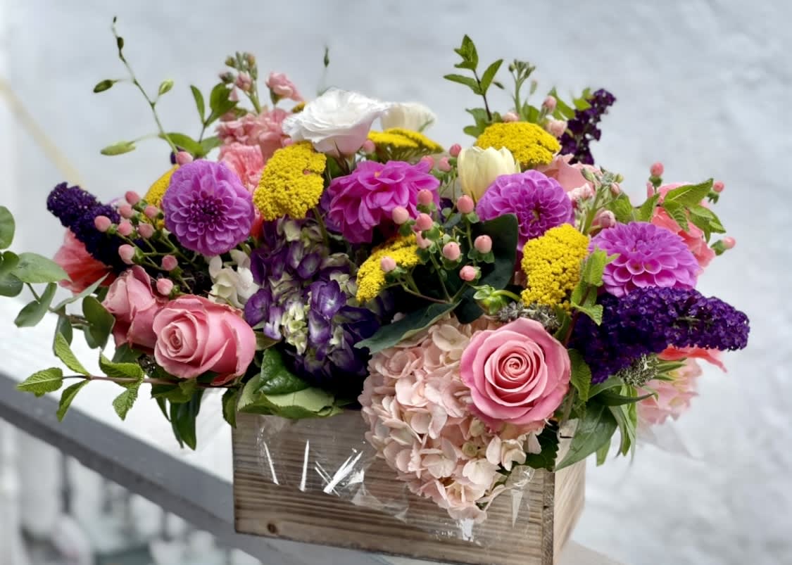 Colorful mixed flower arrangement in a wooden box