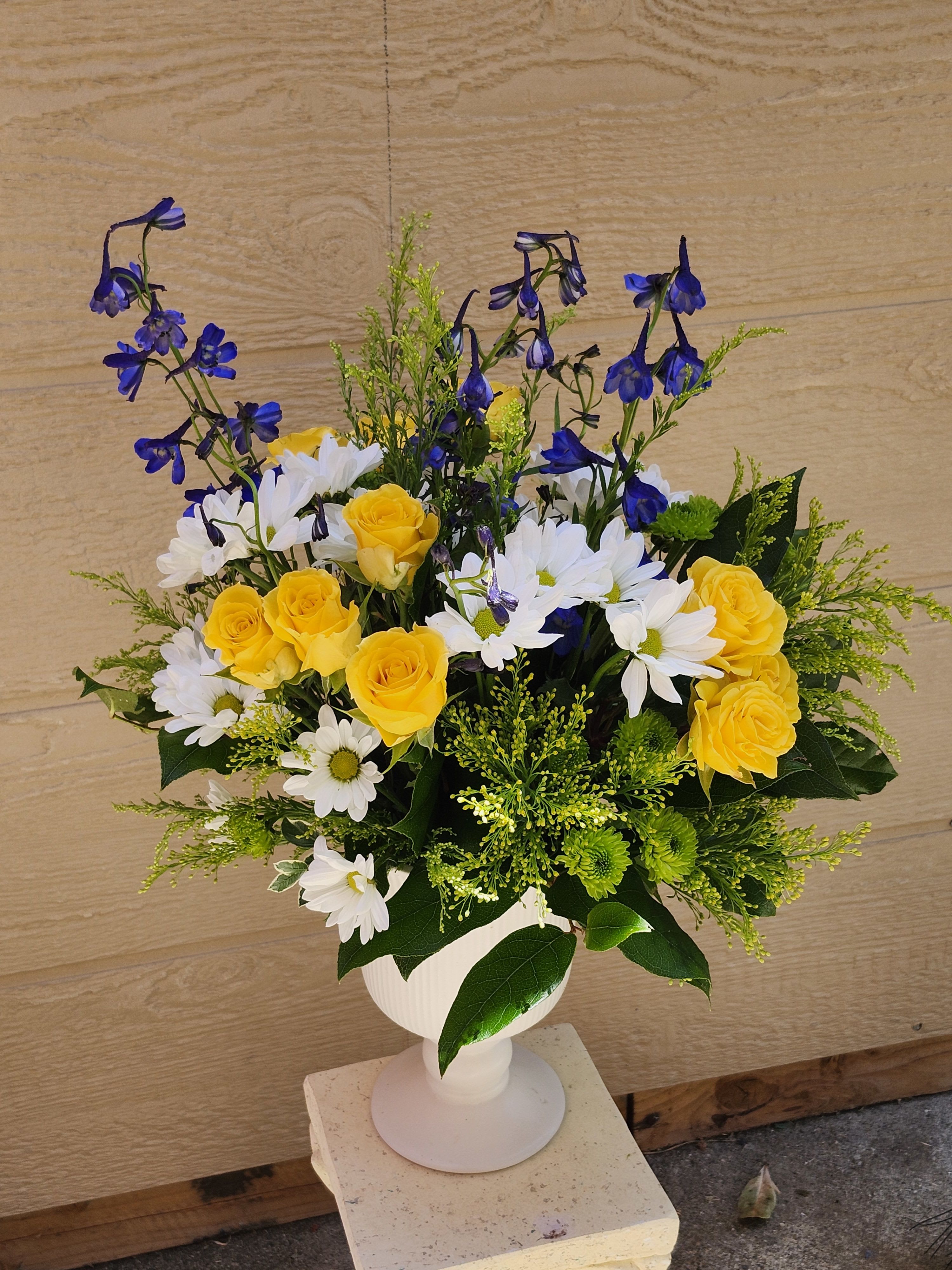 Summer Blue - Great white pedestal vase for a table on any occasion  Ready to go now in cooler.  Yellow spray roses, blue delphiniums, white daises.