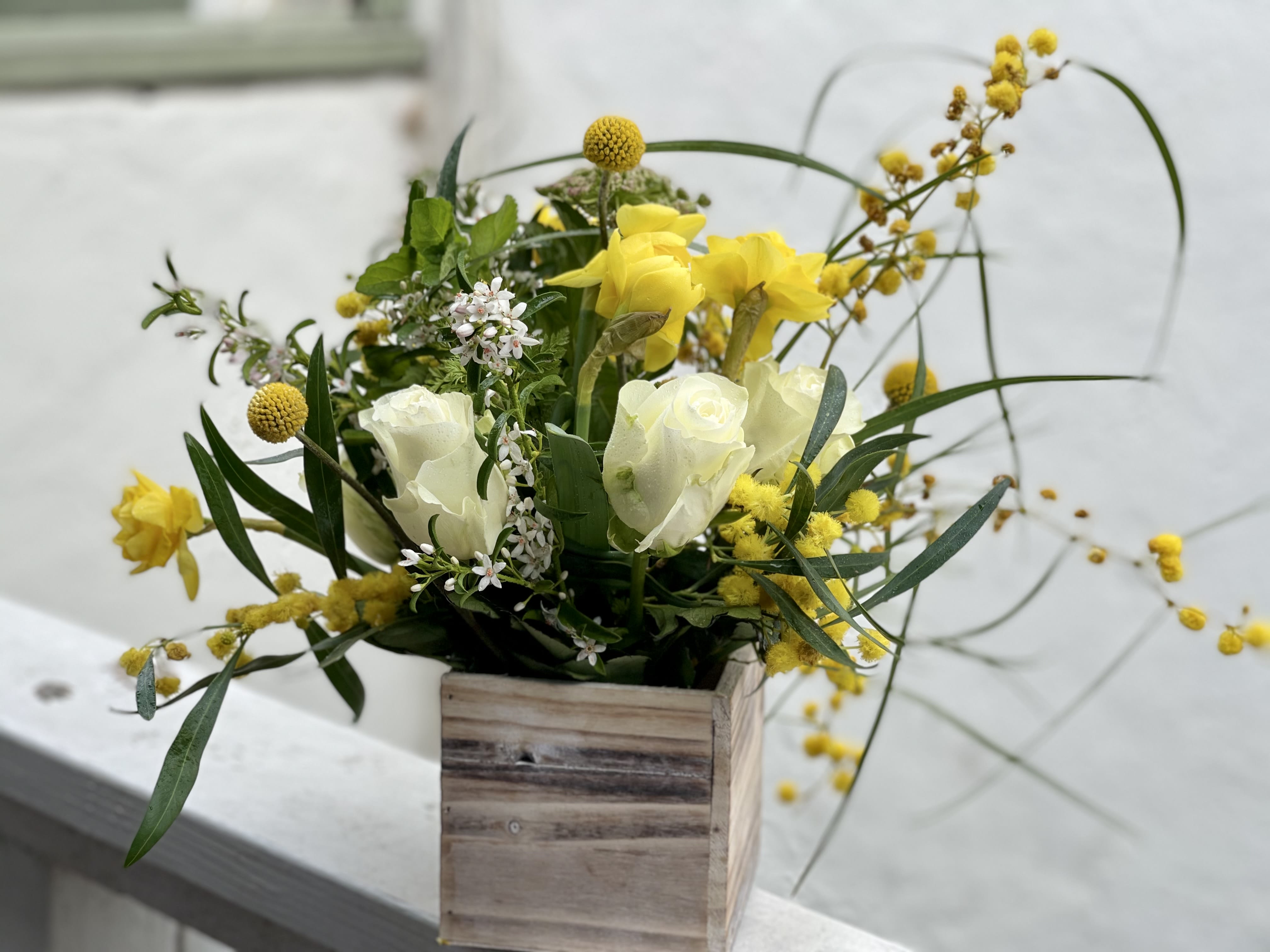 Yellow and white floral arrangement in a wooden box