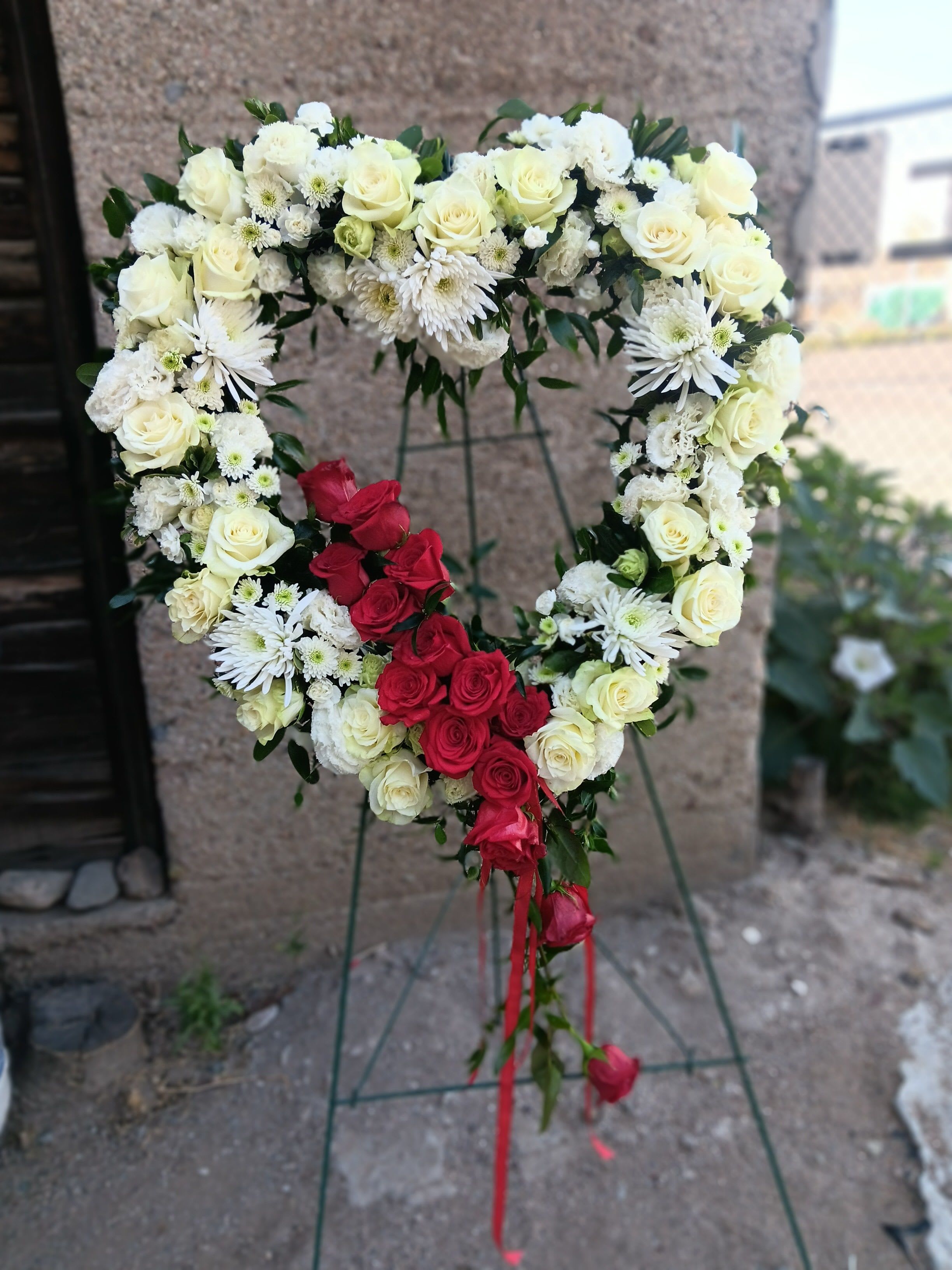 Bleeding Heart - Garden mix of white flowers with a dozen red roses and red ribbons to give the bleeding heart look.