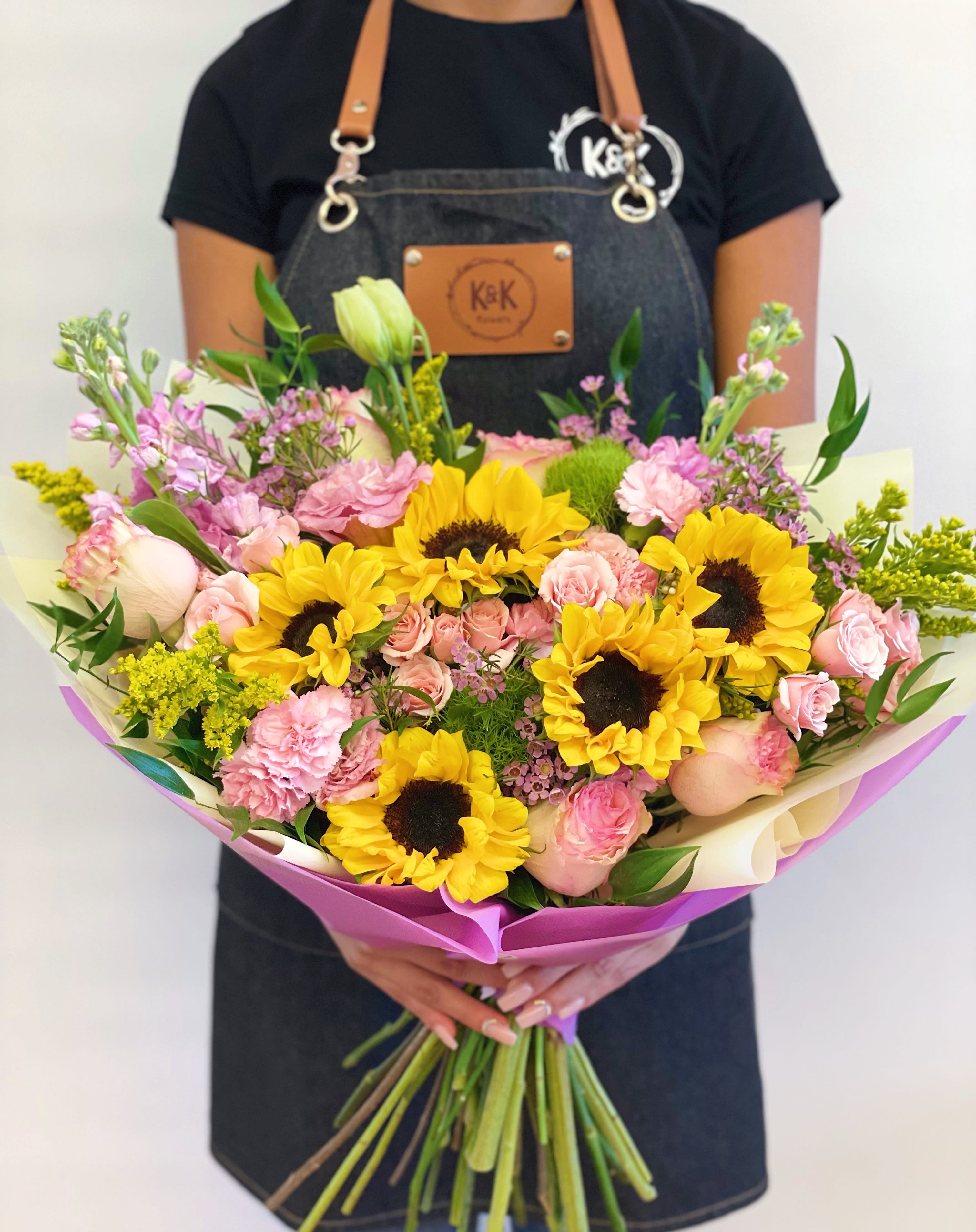 Large loose style bouquet bright - Mixed flowers bouquet, from romantic and gentle to an edgy and interesting look. A bright mix of sunflowers, roses, spray roses, lisianthus, and stock. Perfect for a Birthday, thank you, or to cheer someone up on a rainy day. All bouquets come without a vase. You can choose a vase at the add-on section