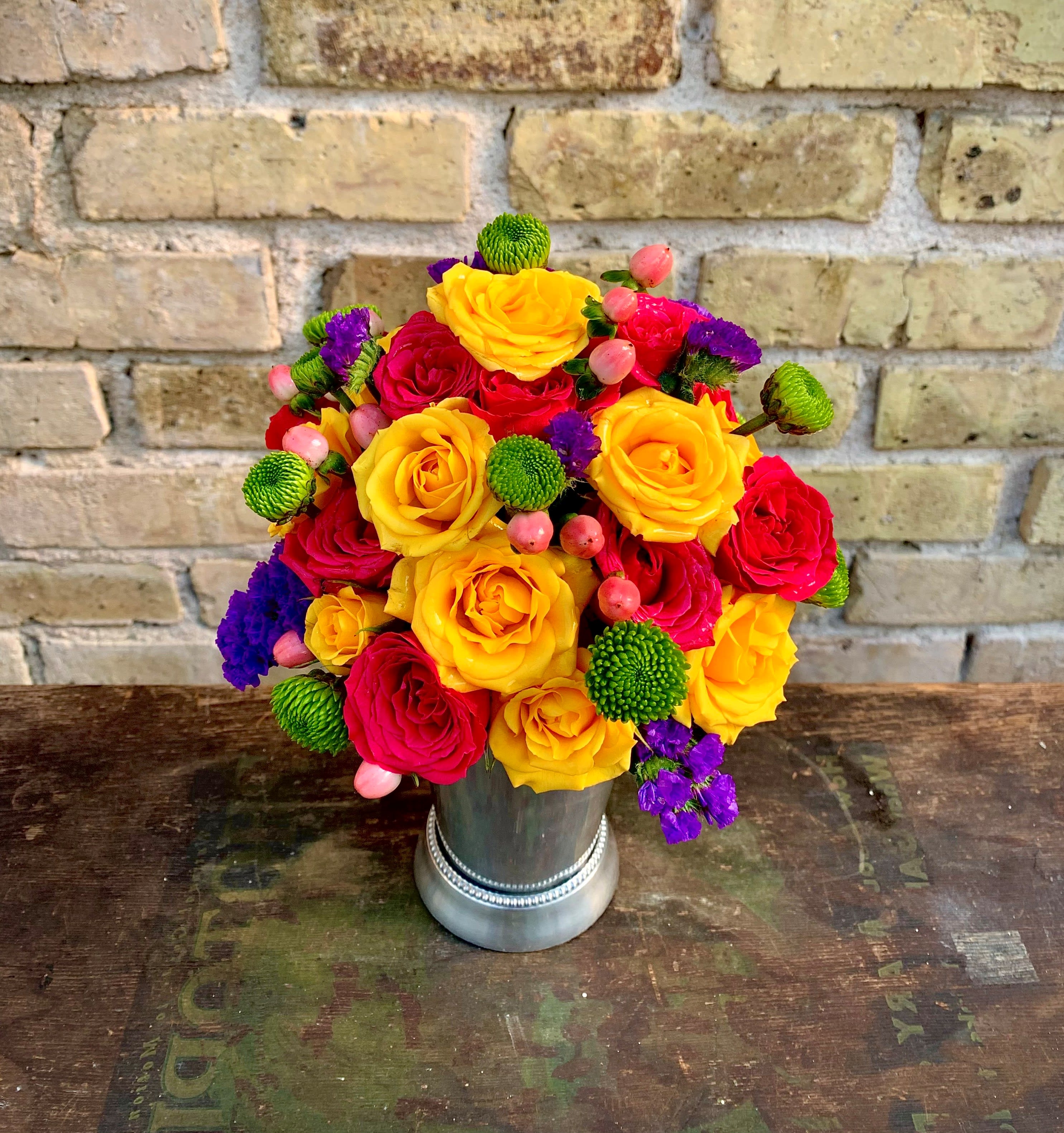 Bright bouquet of yellow and red roses in a silver vase