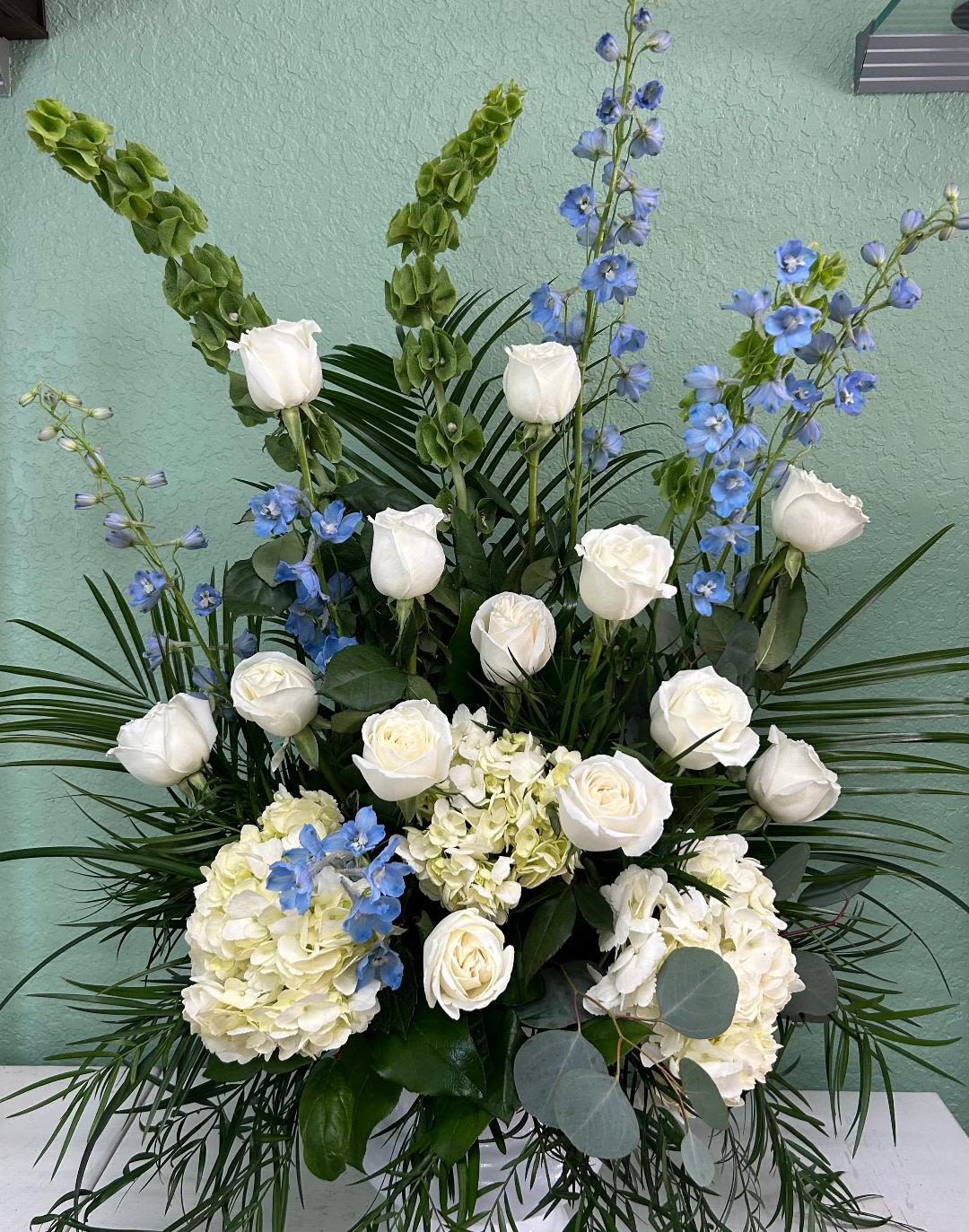 CFS118 - A alter piece style arrangment of high end white, blue and greens flowers such as roses, hydrangeas, bells of ireland and blue delphinium. 
