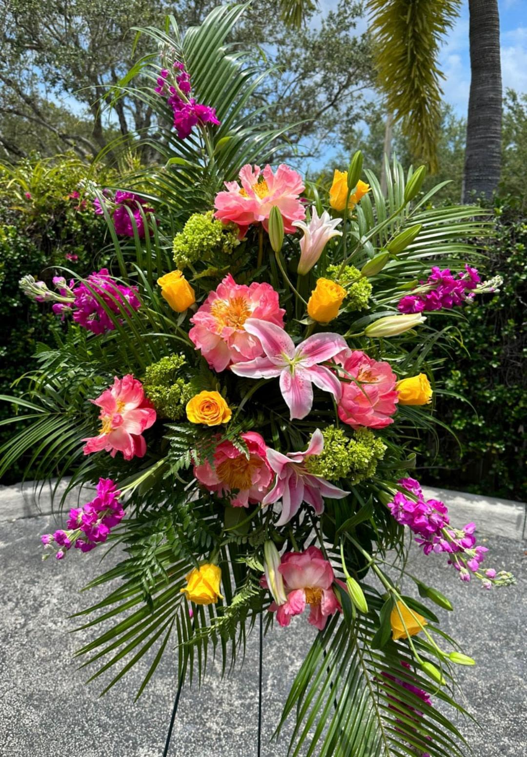 CFS112 - A standing spray for a funeral service with high end blooms in spring colors such as peonies, roses, lilies, stock and other flowers. 