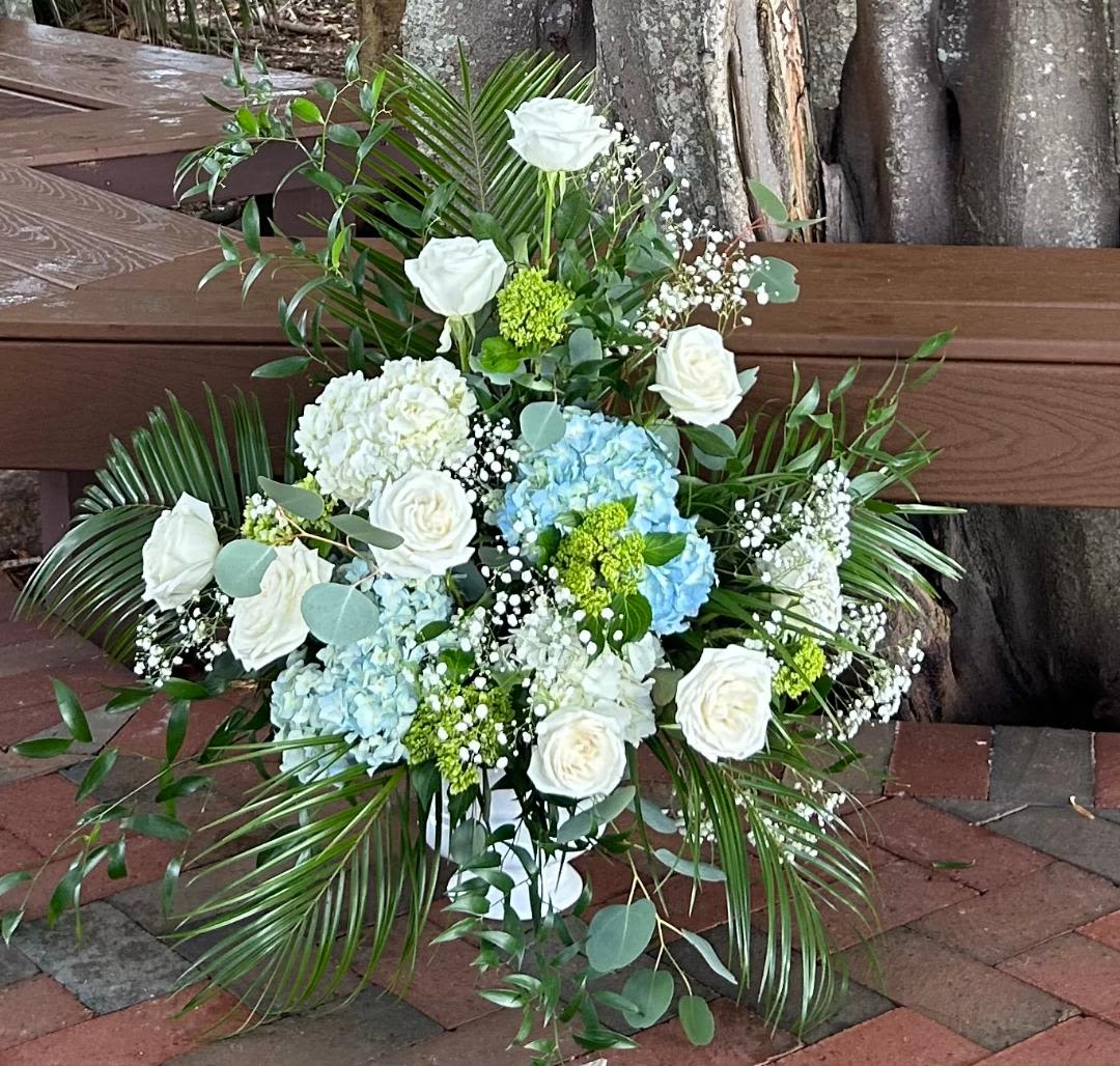 CFS103 - An alter style piece arrangment for a service in white, green and blue flowers such as roses and hydrangeas. 