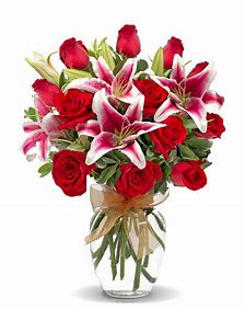 Bouquet of red roses and pink lilies in a clear glass vase