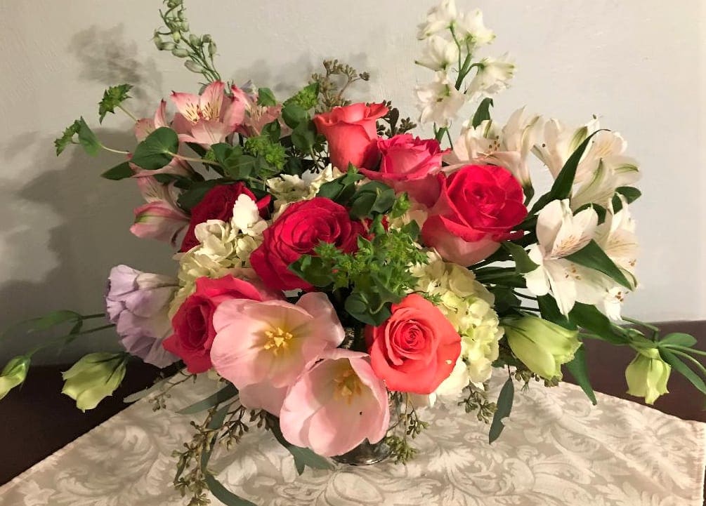Mixed bouquet of roses, lilies, and alstroemeria in a glass vase