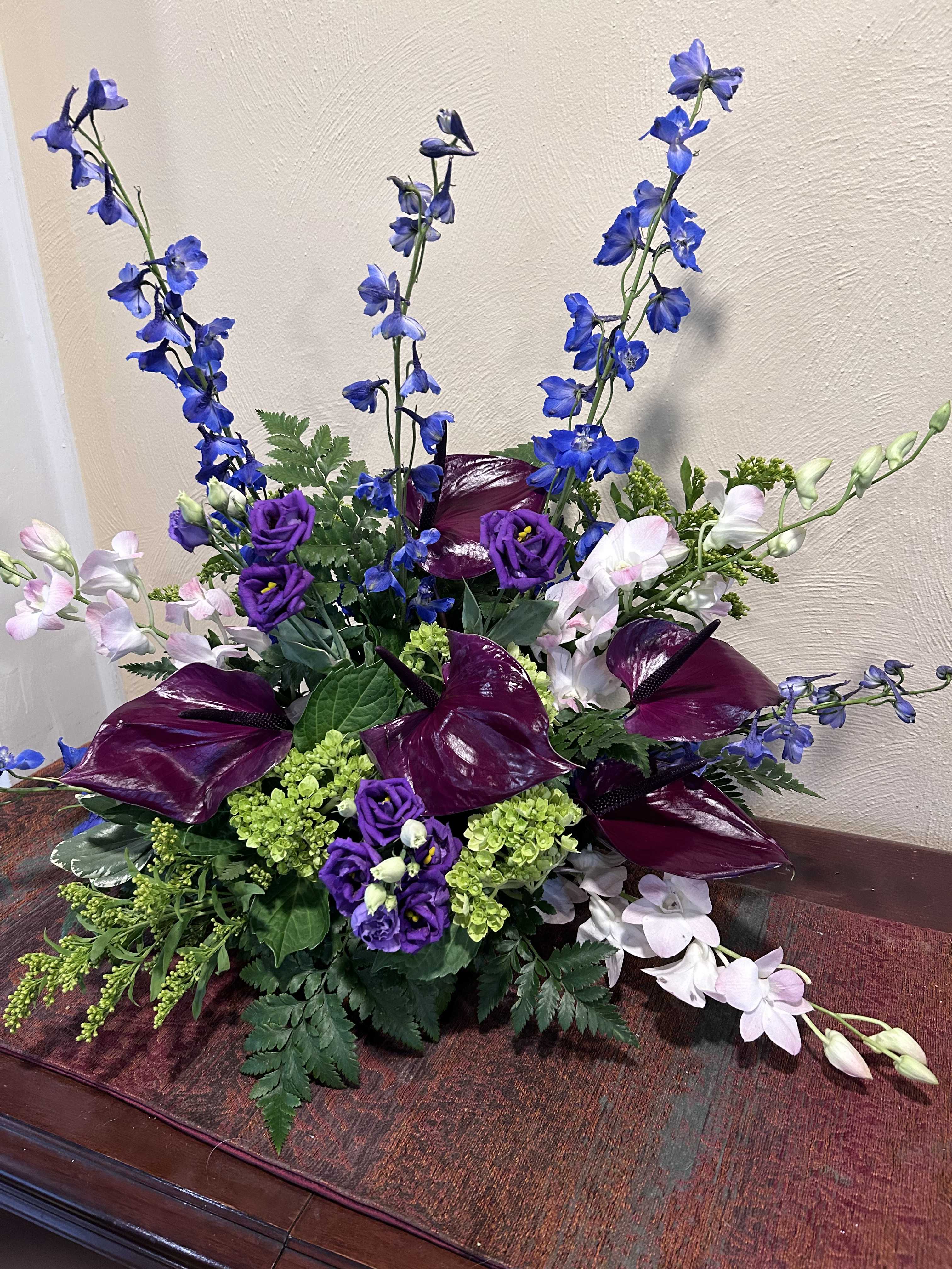 Purple and blue floral arrangement with tall spikes and dark calla lilies