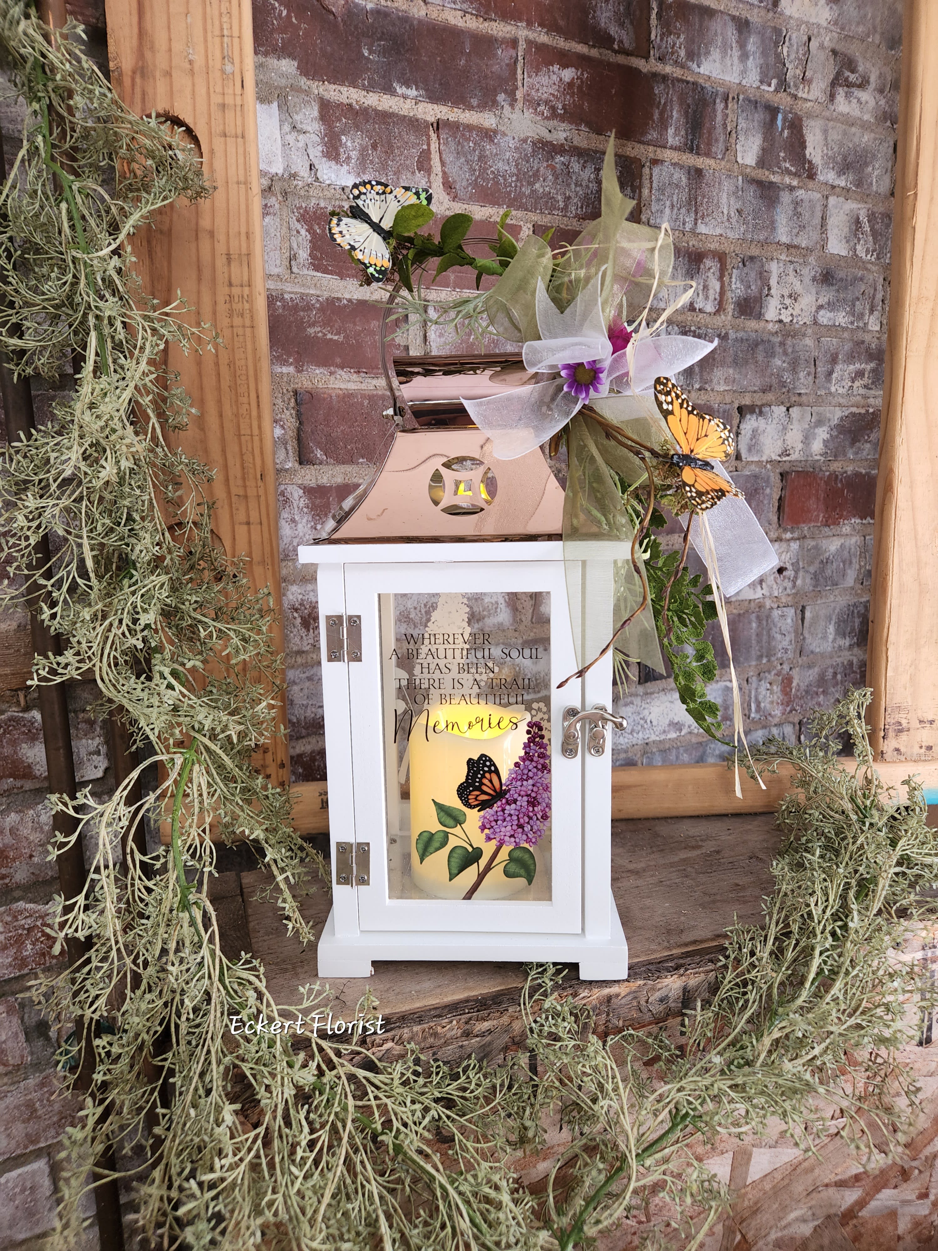 Decorative memorial lantern with a candle, ribbon, and butterfly accents