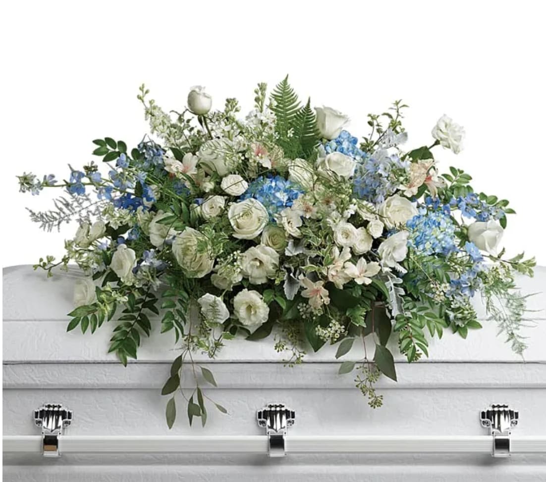White and blue floral casket spray with roses and hydrangeas