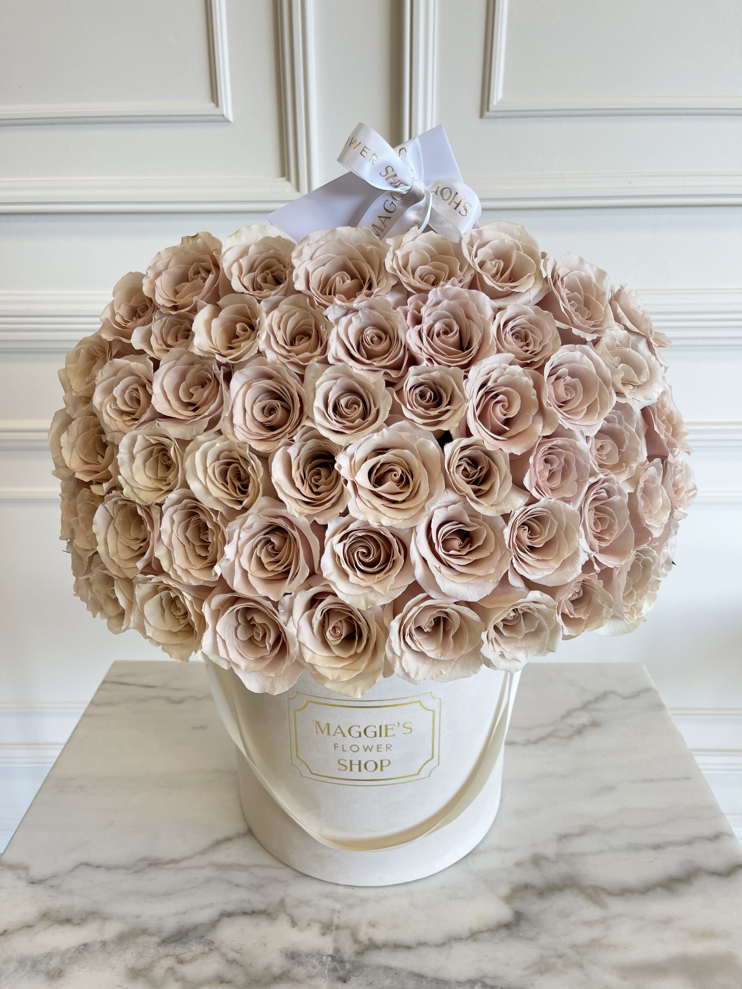 Large bouquet of blush roses in a white hat box with a ribbon bow