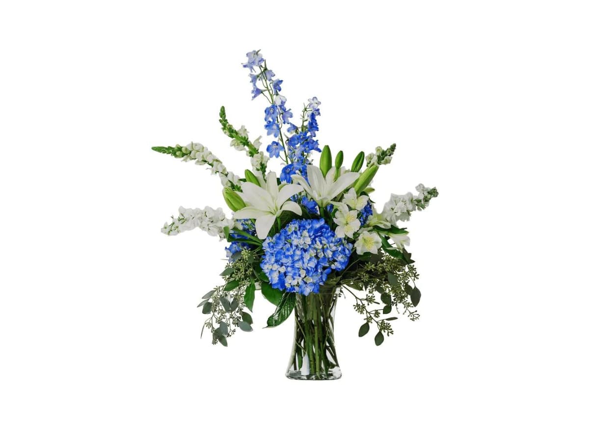 Blue and white floral arrangement in a clear glass vase