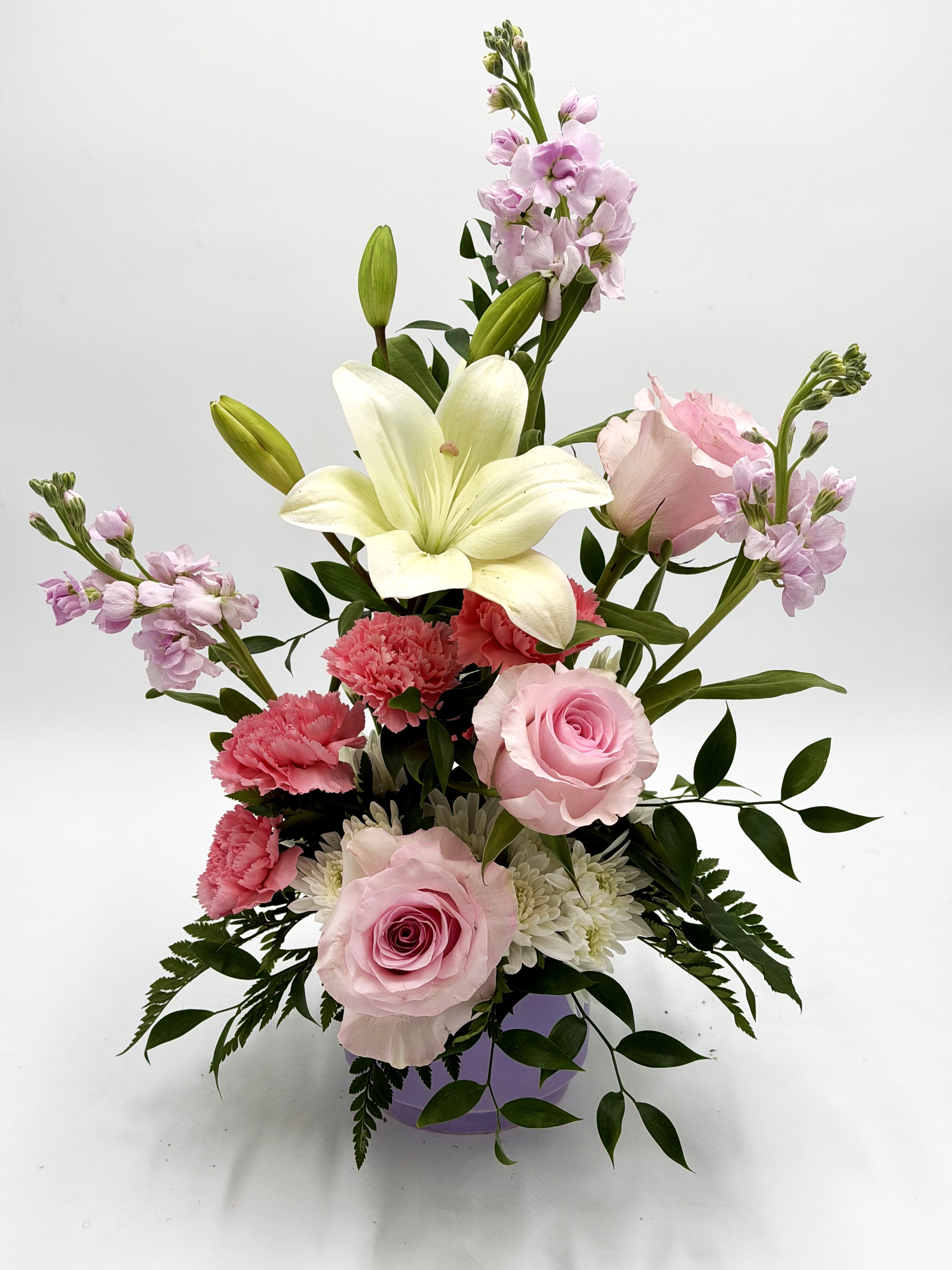 Rosy Daydream - Rosy Daydream is a soft and romantic arrangement designed with delicate shades of blush pink and creamy white blooms. Featuring elegant roses, fragrant lilies, cheerful carnations, and seasonal accents, this arrangement brings a graceful touch to any occasion. Perfect for birthdays, anniversaries, get well wishes, or simply brightening someone’s day with a little beauty and love.