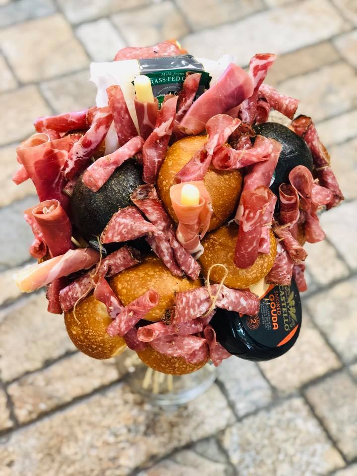 Bouquet made of cured meats and cheese in a clear vase