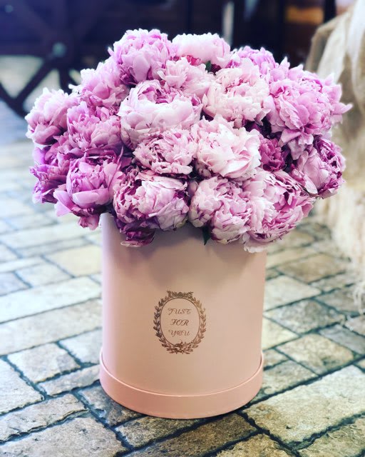 Pink peonies arranged in a blush round box