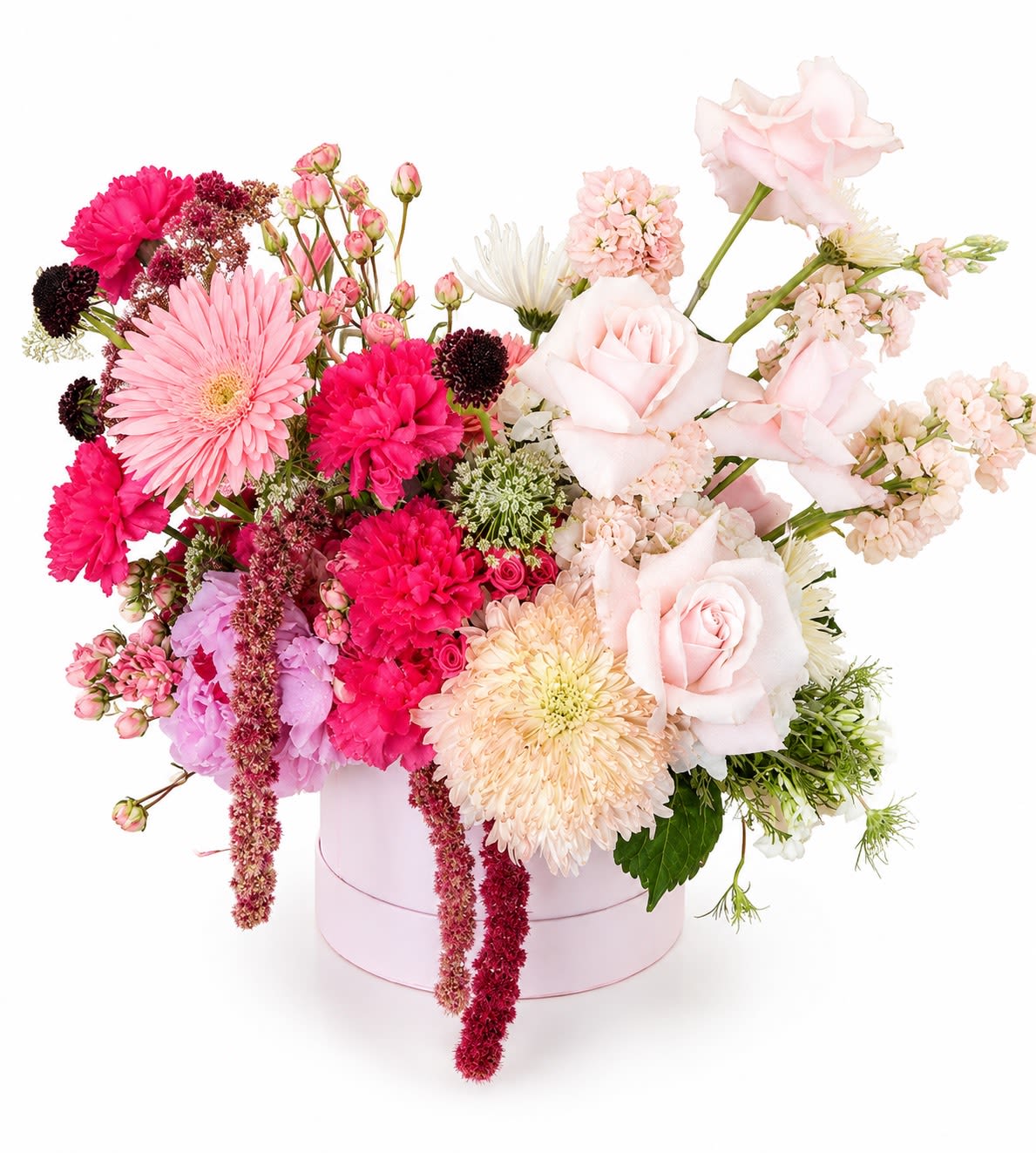 Electric Blush - Pale pink roses and hot pink carnations pop against clouds of soft hydrangea in a rounded pink hat box-Electric Blush is a lush "just because" flower arrangement that reads like a love note. Perfect as a birthday bouquet, anniversary surprise, or thinking-of-you gift, its blush-to-burgundy palette and whimsical pops of lavender and white make the recipient feel genuinely celebrated and seen.  This full, layered design mixes roses, carnations, hydrangeas, ranunculus, stock, sweet pea, delphinium, spray roses, chrysanthemums, daisies and other seasonal blooms for texture and movement. Taller stems and a few trailing elements extend beyond the compact round pink box for an abundant, overflowing look; the color story moves from delicate peach-pink to vivid hot pink with green foliage accents for contrast. The arrangement arrives ready to display in the charming hat box-no vase required.  Give Electric Blush to new parents, a friend moving into a new home, or the person whose birthday or milestone you want to uplift; it's equally sweet for Mother's Day, a quinceañera, or a romantic gesture. To keep the flowers happy, place in a cool spot away from direct sun and refresh the water (or floral foam) when you notice it running low-this way the recipient enjoys that celebratory bloom longer.
