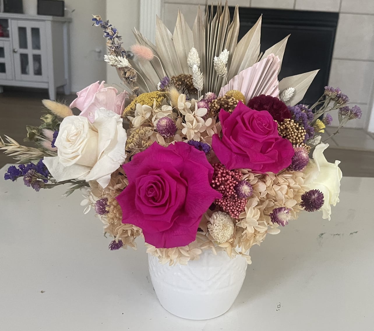 Bouquet of hot pink and white roses in a white vase
