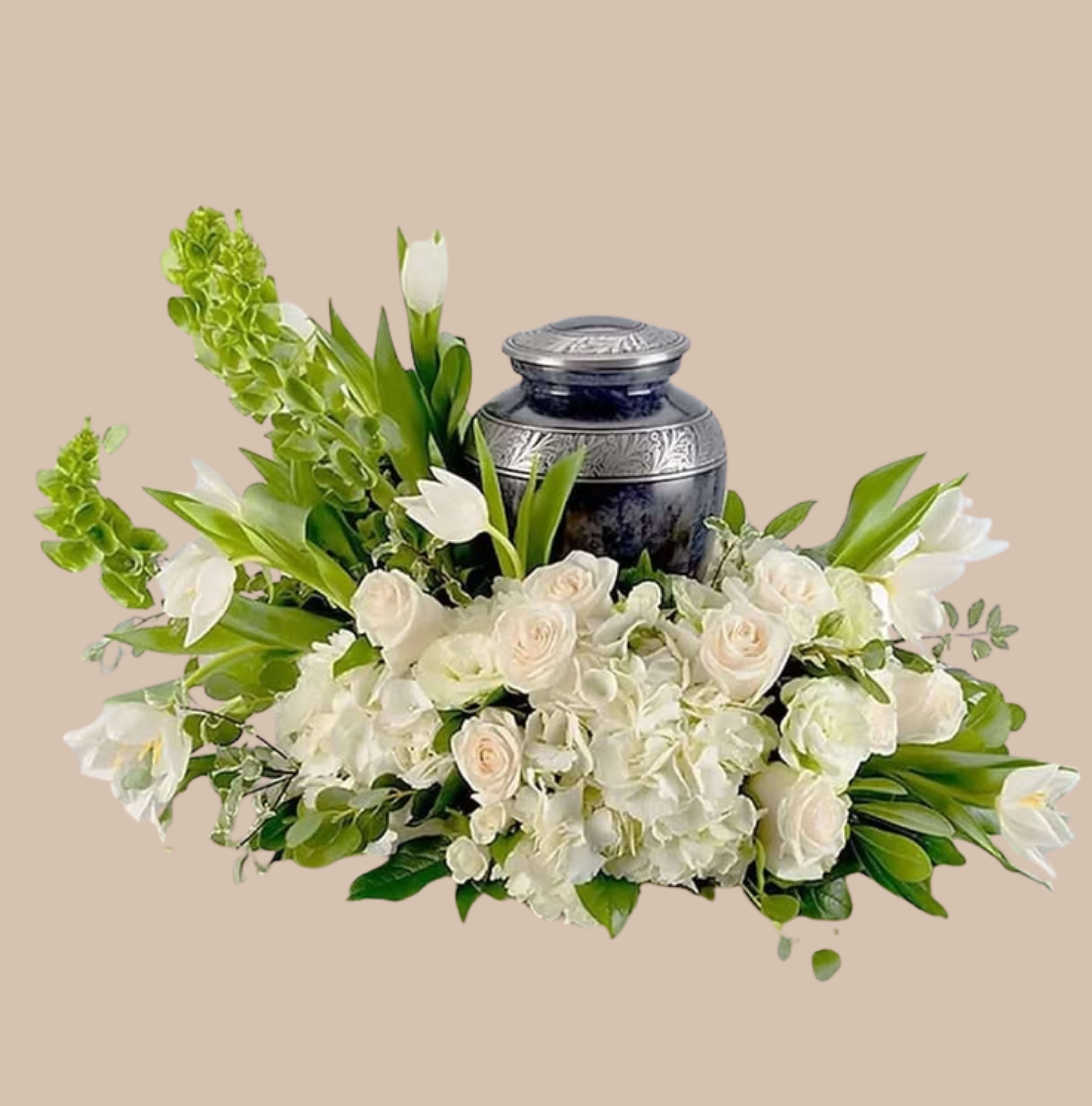 White Meadow Tribute - A serene cluster of white roses, hydrangeas, and lilies forms the centerpiece of this formal sympathy arrangement-perfect as a funeral tribute or a comforting display for a memorial service. The White Meadow Tribute is designed to convey quiet reverence; the primarily white palette with bright green foliage creates a calm, restorative impression the person you're thinking of will feel as respectful and thoughtfully chosen.  Dense, low-slung groupings of full white roses and fluffy hydrangeas are complemented by elegant white lilies, spray roses, lisianthus, and tall accent blooms for subtle vertical contrast. Everything is arranged around a dark, lidded decorative urn that gives the composition a polished, substantial presence suitable for a tabletop or front-of-casket display. The mix of textures-from the soft hydrangea heads to the sculpted rose petals and leafy greens-adds depth while keeping the overall silhouette clean and formal.  This arrangement reads as a quiet expression of sympathy that honors a life with understatement and grace; it's the kind of tribute that helps family members feel seen and supported during services. The low, wide dimensions make it easy to place on a service table or reception surface; care is simple-keep the blooms in the provided vase/urn with fresh water and away from direct heat to maintain freshness through the service.