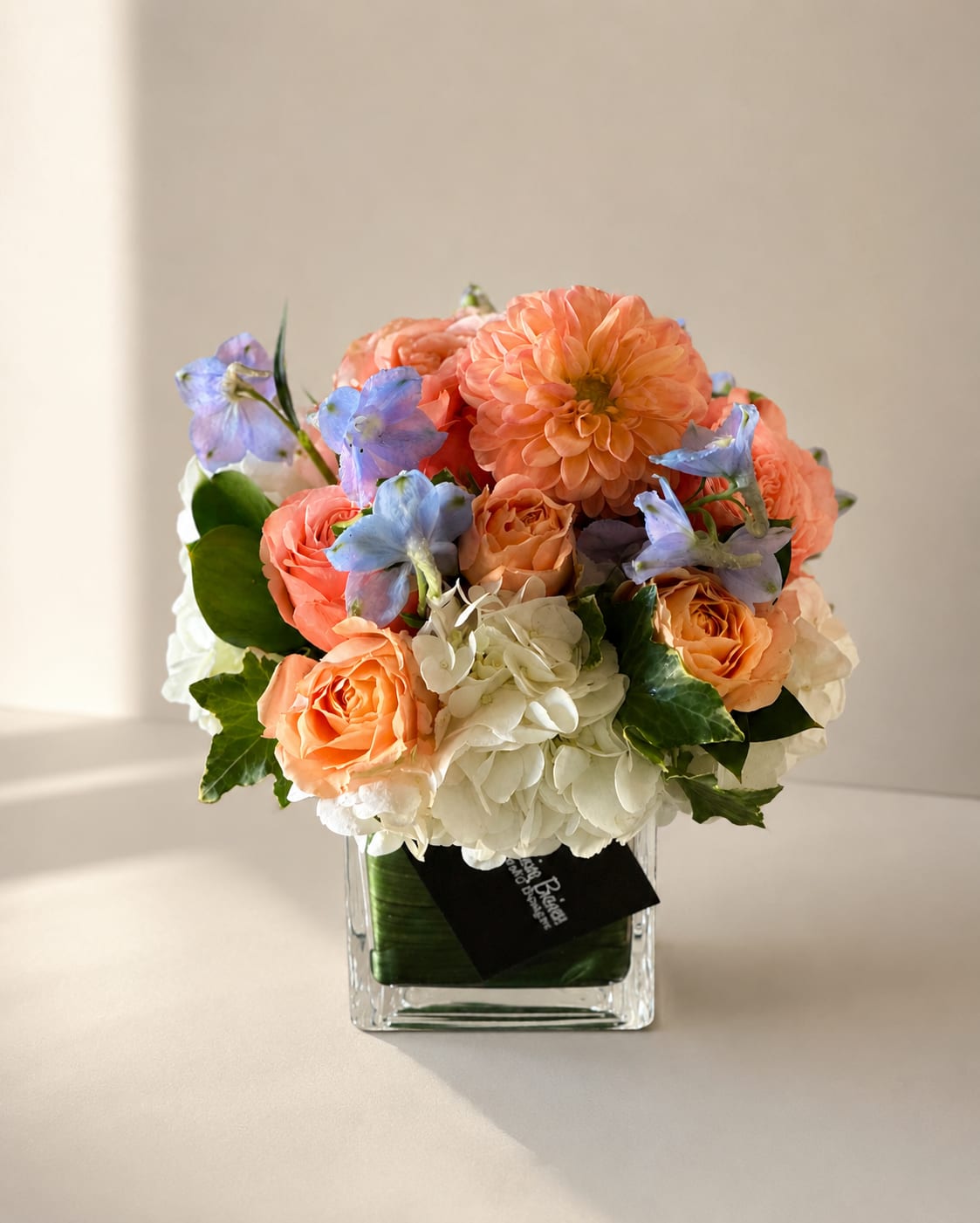 Dottie – Garden Peach Rose &amp; Dahlia Arrangement | Same-Day Flower Delivery Los Angeles - Sweet, graceful, and effortlessly elegant, Dottie is a garden-inspired flower arrangement designed to brighten any occasion. Featuring luxurious peach roses, a stunning peach dahlia, delicate blue delphinium, and lush white hydrangea, this charming design is arranged in a modern glass vase for a timeless and sophisticated look.  With its soft pastel tones and romantic textures, Dottie makes a beautiful gift for birthdays, anniversaries, thank yous, get well wishes, new baby celebrations, sympathy sentiments, or simply to let someone know you're thinking of them. Its cheerful blend of peach, ivory, and soft blue flowers creates a fresh and uplifting arrangement that complements any home or office.  Handcrafted with premium blooms by My Blooming Business, Dottie is thoughtfully designed to deliver joy and beauty with every stem. We proudly offer same-day flower delivery in Los Angeles, Eagle Rock, Glendale, Pasadena, Highland Park, South Pasadena, Burbank, Los Feliz, Atwater Village, and surrounding communities.  Whether you're searching for flower delivery in Los Angeles, a trusted florist in Eagle Rock, or an elegant garden-style flower arrangement, Dottie is a lovely choice for celebrating life's special moments or sending a heartfelt surprise.  Occasions Celebration Flowers Anniversary Flowers Get Well Flowers Thank You Flowers Thinking of You Flowers New Baby Flowers Just Because Flowers Sympathy Flowers